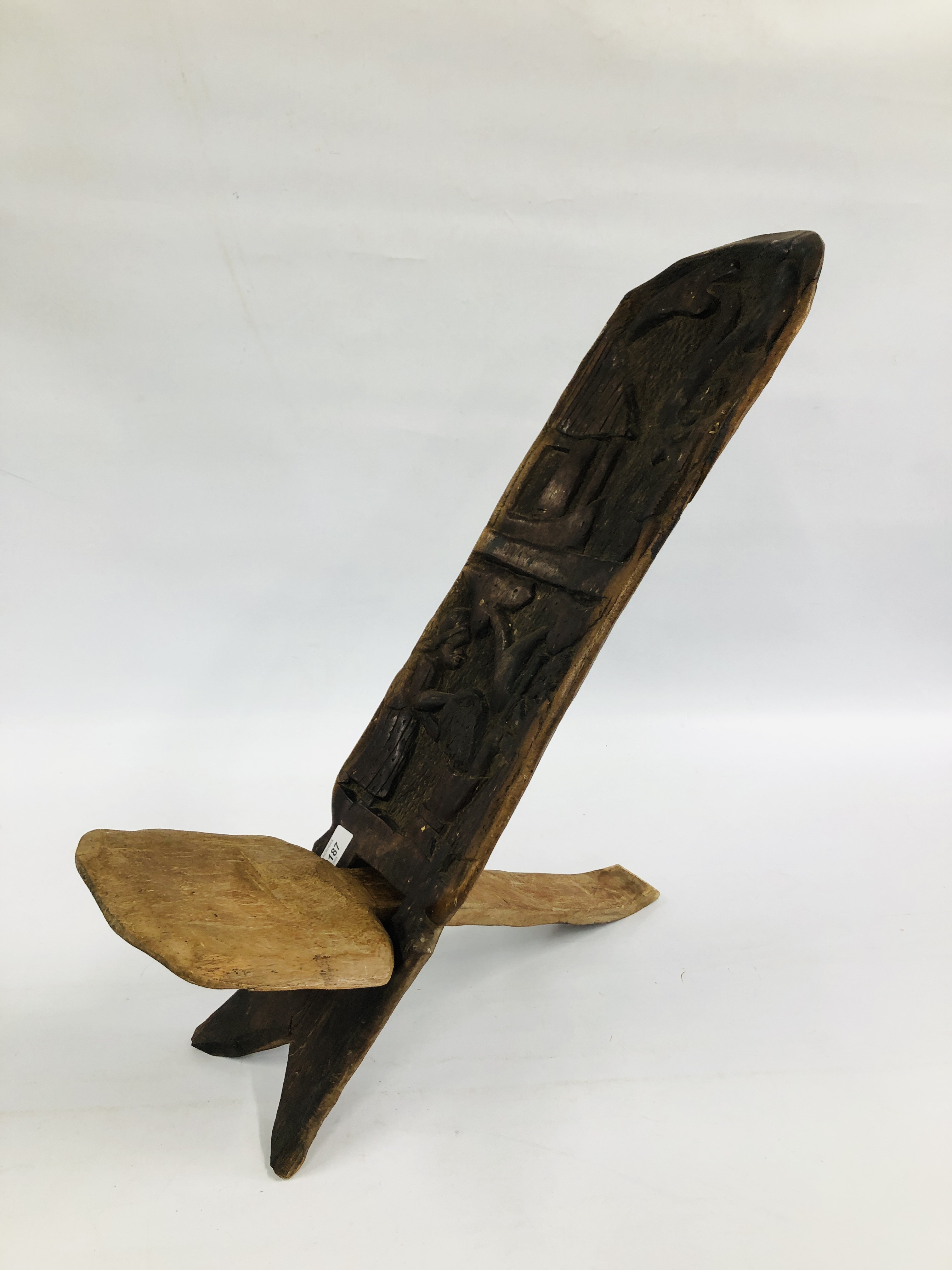 A VINTAGE HARDWOOD CARVED SELF SUPPORTING TRIBAL SEAT.