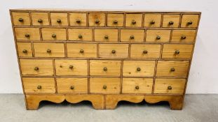 AN EARLY C19TH WAXED PINE APOTHECARY CHEST WITH 33 DRAWERS OF GRADUATED SIZE W 145CM.