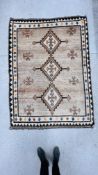 A C20th TRIBAL RUG, THE THREE CENTRAL LOZENGES ON A LIGHT BROWN FIELD,