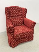 A MODERN EASY CHAIR WITH RED / GOLD PATTERNED LOOSE COVERS.