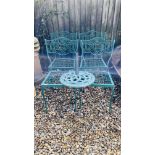 A SET OF FOUR GREEN METAL GARDEN CHAIRS AND CAST IRON PARASOL BASE AND A GARDEN TABLE WITH STONE