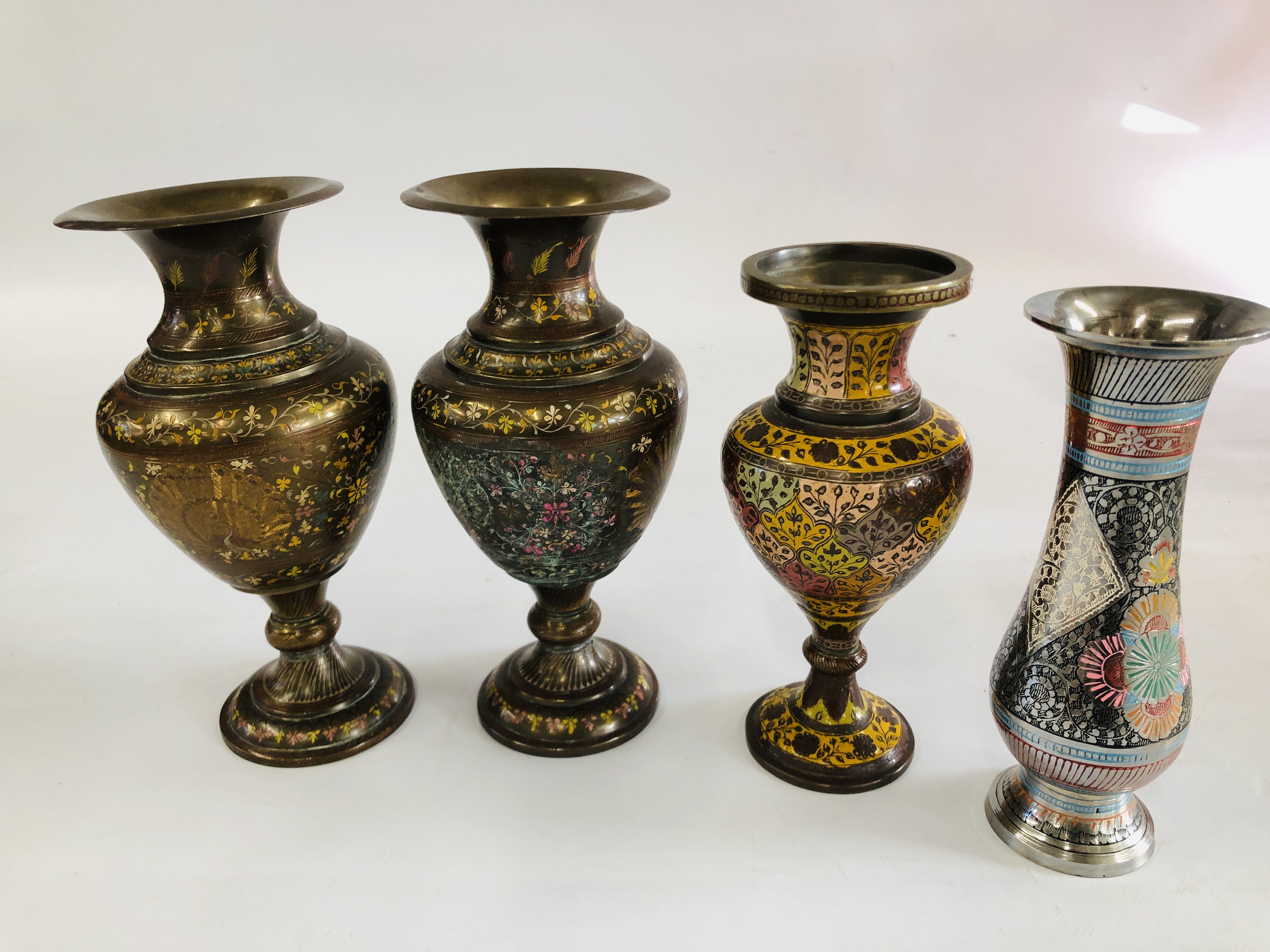 A PAIR OF BRASS VASES WITH CHASED PEACOCK AND HAND PAINTED DECORATION ALONG WITH A SMALLER VASE OF