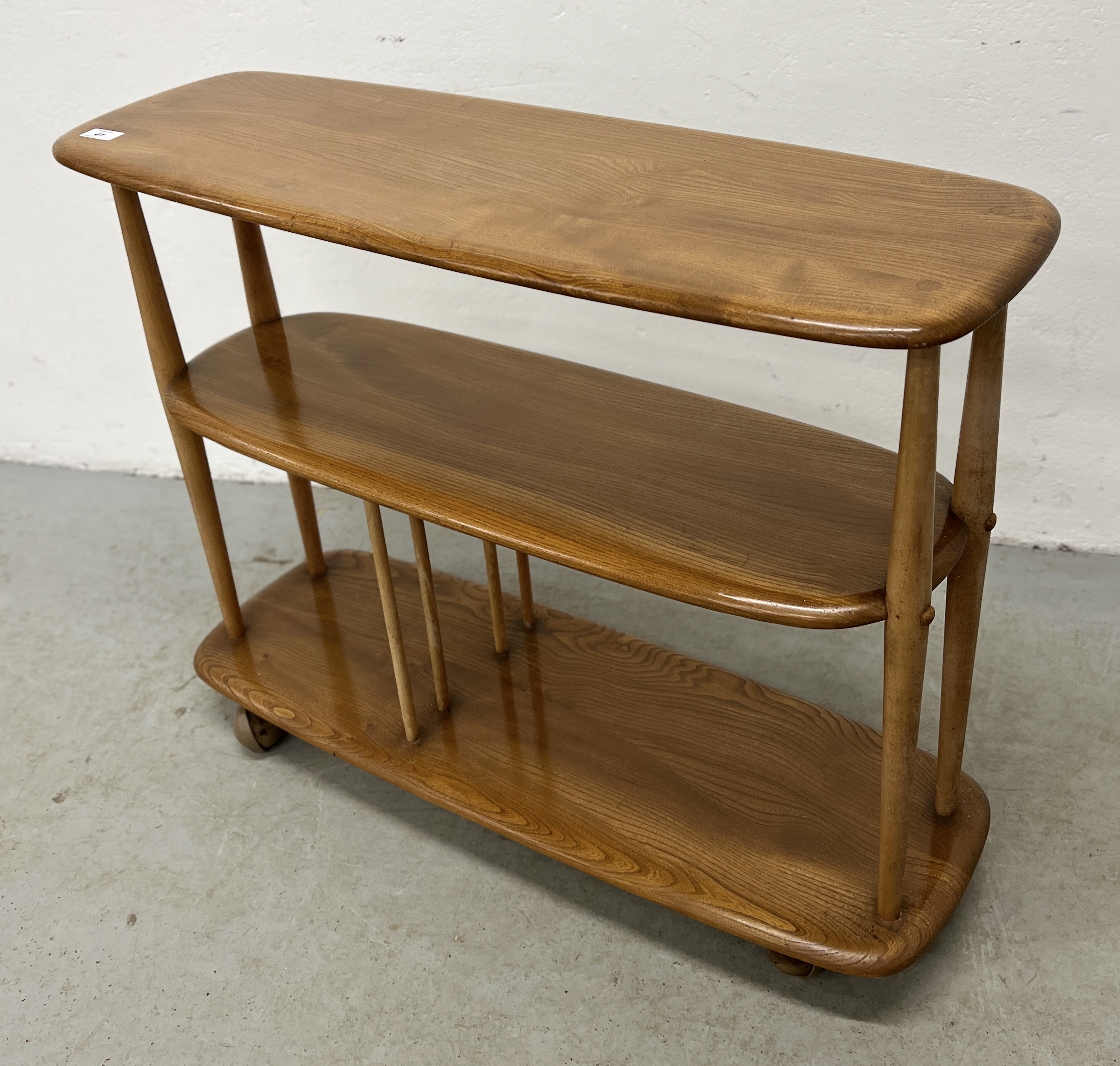 AN ERCOL WINDSOR GIRAFFE TROLLEY BOOKCASE - W 91CM X D 31CM X H 71CM.