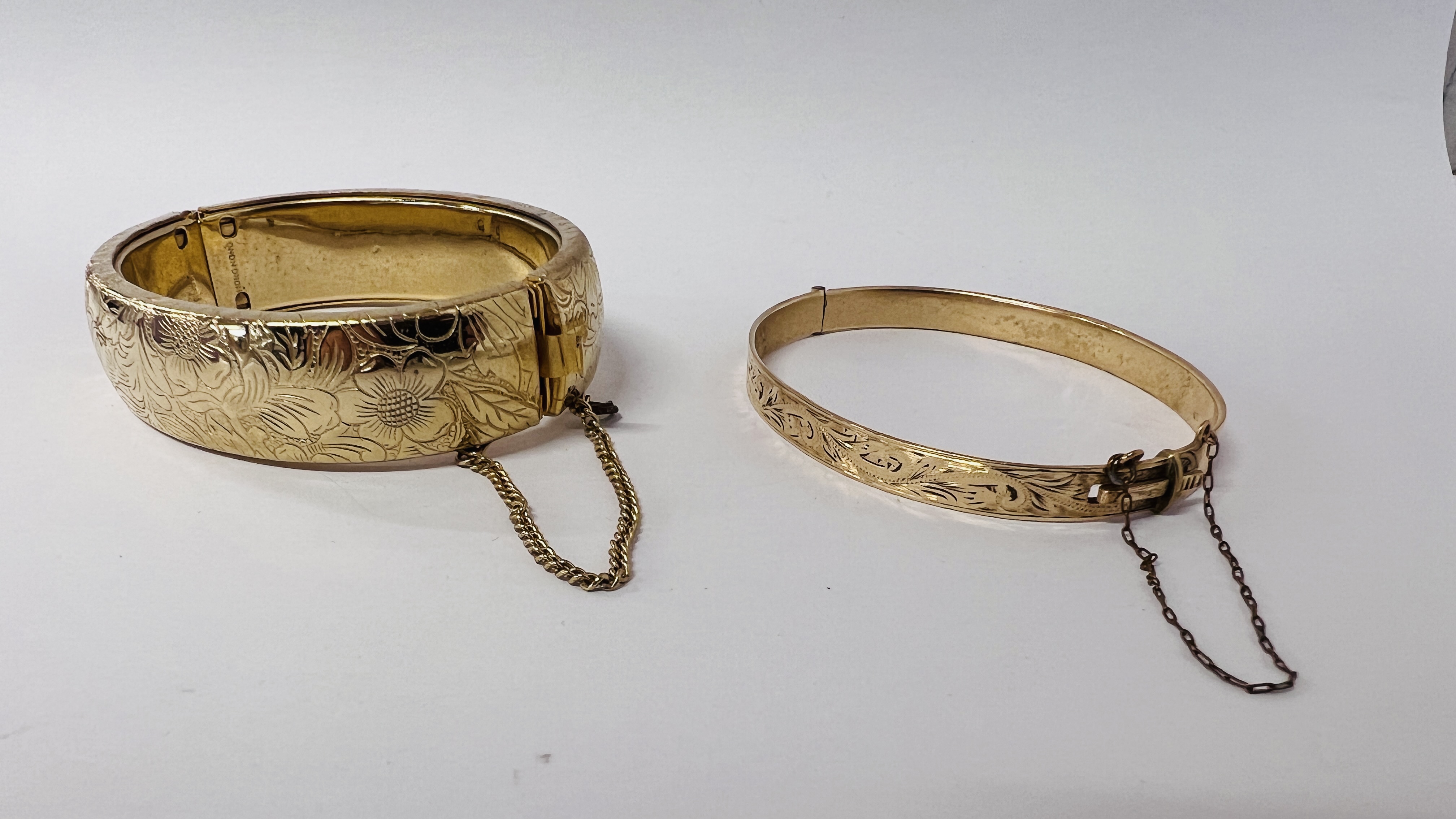 TWO GOLD TONE HINGED BANGLES.