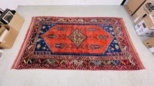 AN EASTERN CARPET CENTRAL DIAMOND SHAPED MEDALLION, PRESENTED ON A RED GROUND, 2.9 X 1.6M.