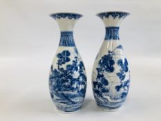A PAIR OF DECORATIVE BLUE AND WHITE ORIENTAL VASES DEPICTING A PREGNANT WOMAN SEATED AMONGST THE