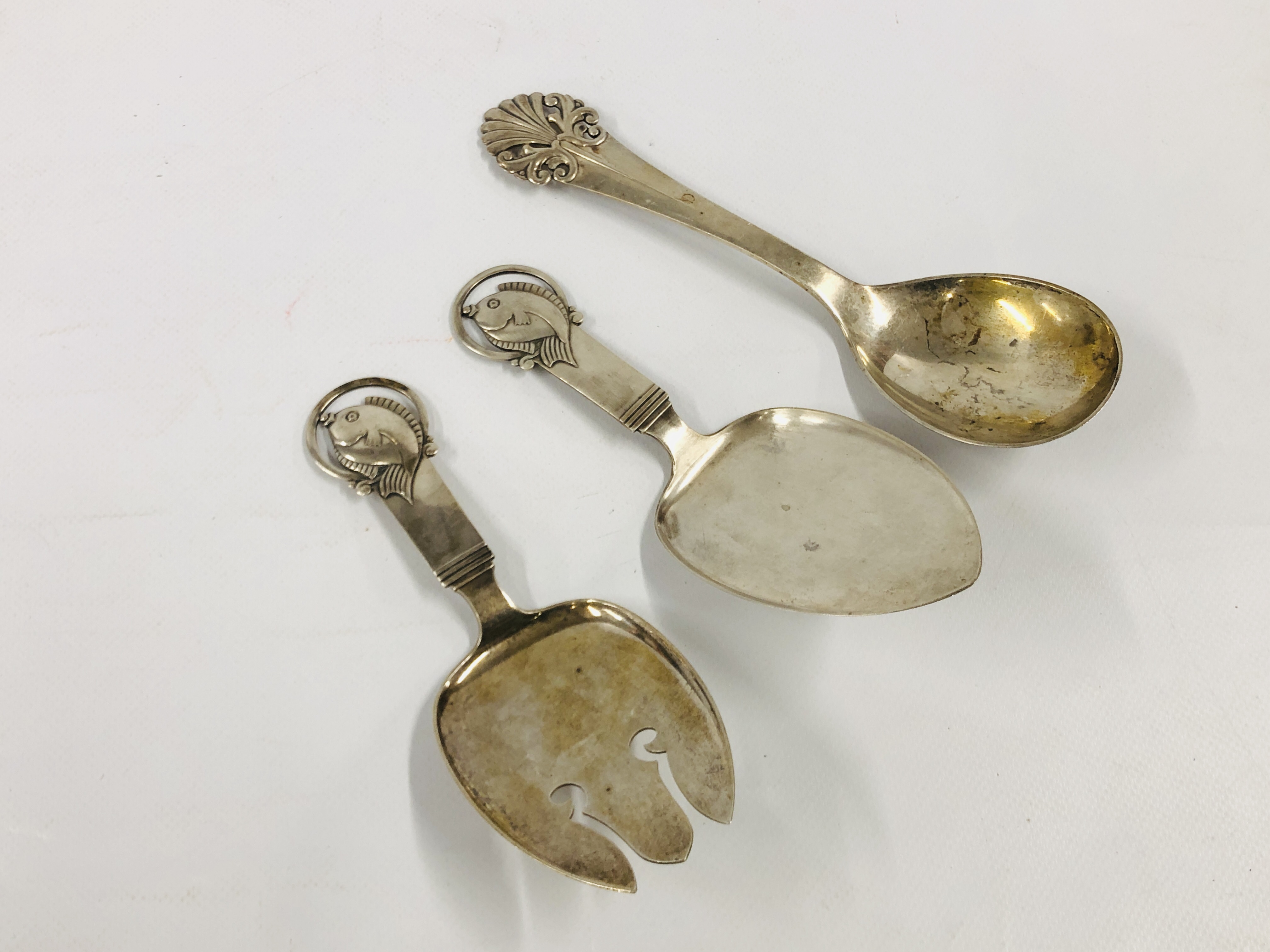 A PAIR OF CONTINENTAL WHITE METAL FISH SERVERS MAKERS SJ ALONG WITH A FURTHER SERVING SPOON BY THE