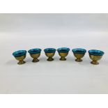 A SET OF SIX MIDDLE EASTERN BRASS GOBLET VESSELS WITH BLUE GLASS LINERS.