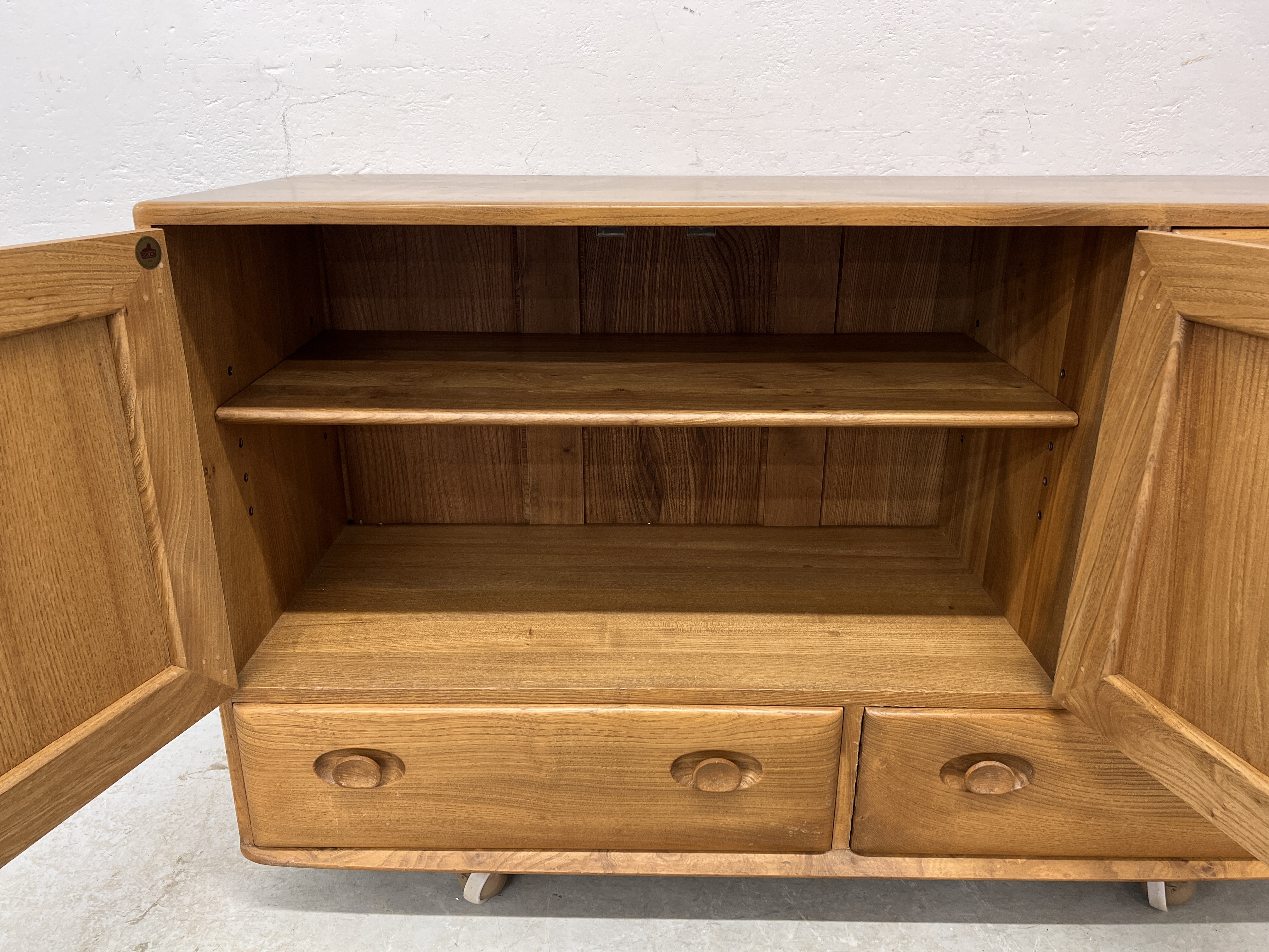 AN ERCOL WINDSOR SIDEBOARD, 3 CUPBOARD DOORS ABOVE 2 DRAWERS W 130CM X D 44CM X H 76CM. - Image 14 of 18