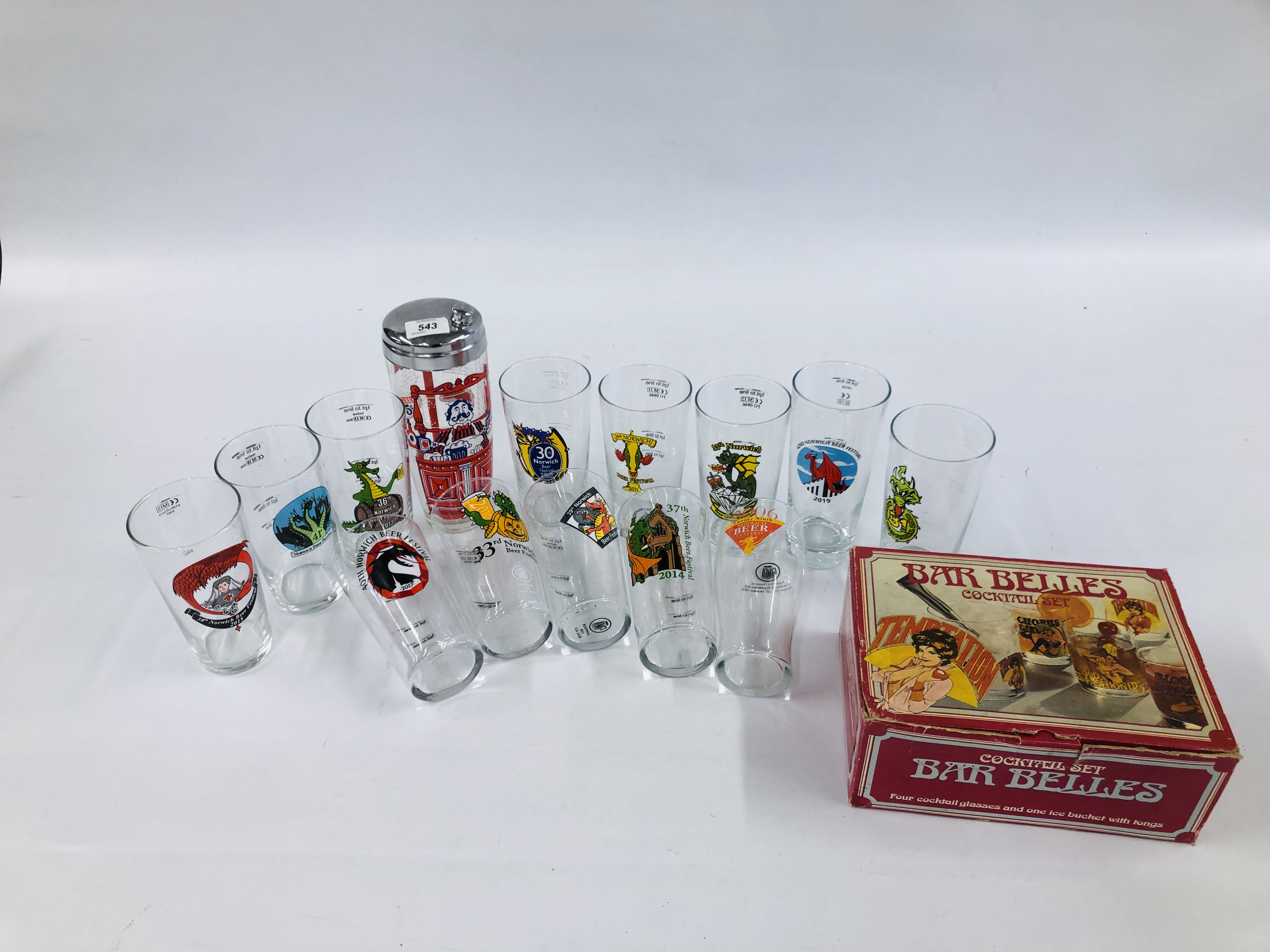 A COLLECTION OF 13 NORWICH BEER FESTIVAL GLASSES ALONG WITH A VINTAGE BOXED SET "BAR BELLES