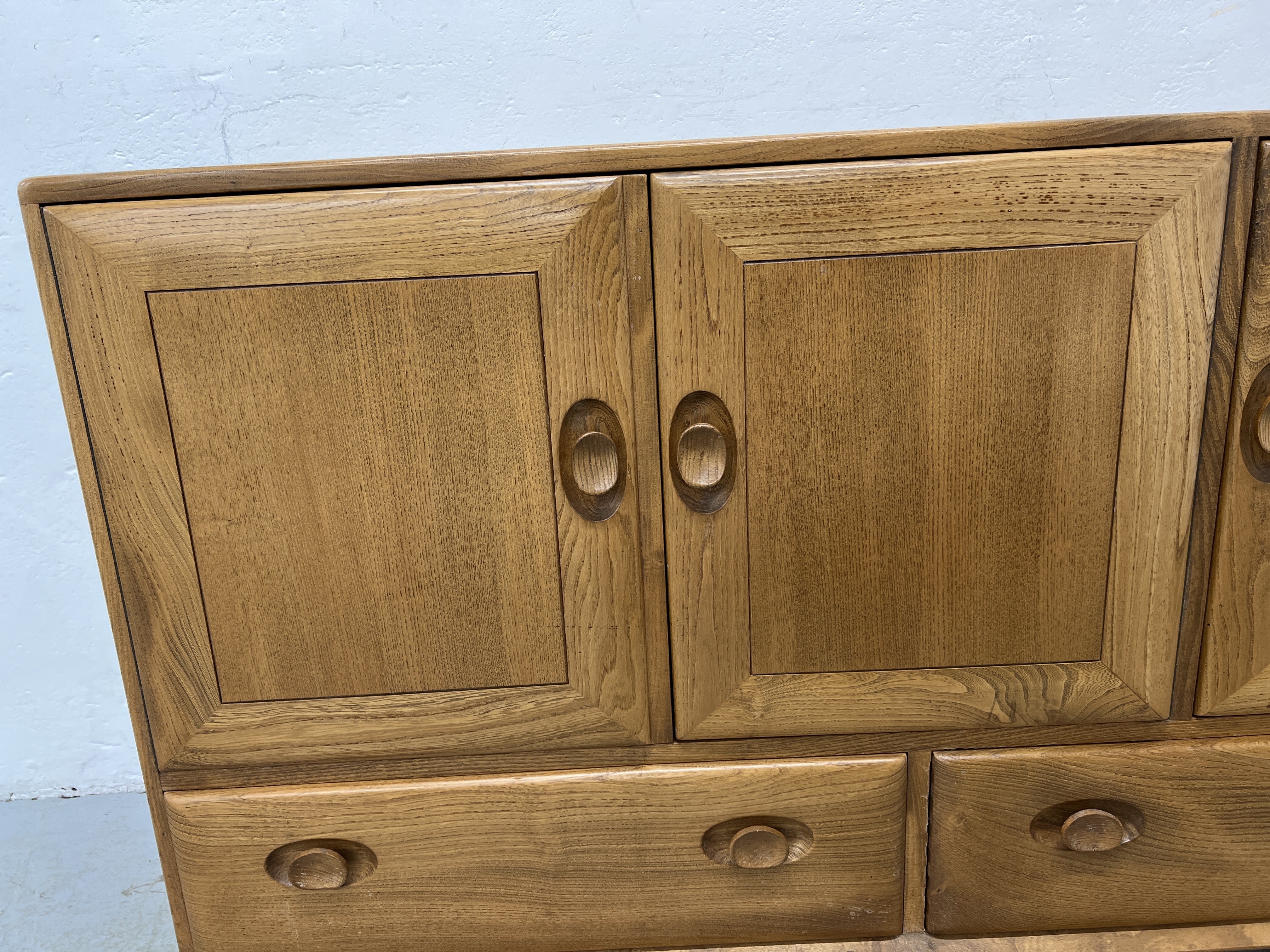AN ERCOL WINDSOR SIDEBOARD, 3 CUPBOARD DOORS ABOVE 2 DRAWERS W 130CM X D 44CM X H 76CM. - Image 10 of 18