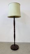 A CARVED HARDWOOD STANDARD LAMP AND SHADE ON A CIRCULAR BASE - WIRE REMOVED - SOLD AS SEEN.