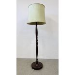 A CARVED HARDWOOD STANDARD LAMP AND SHADE ON A CIRCULAR BASE - WIRE REMOVED - SOLD AS SEEN.