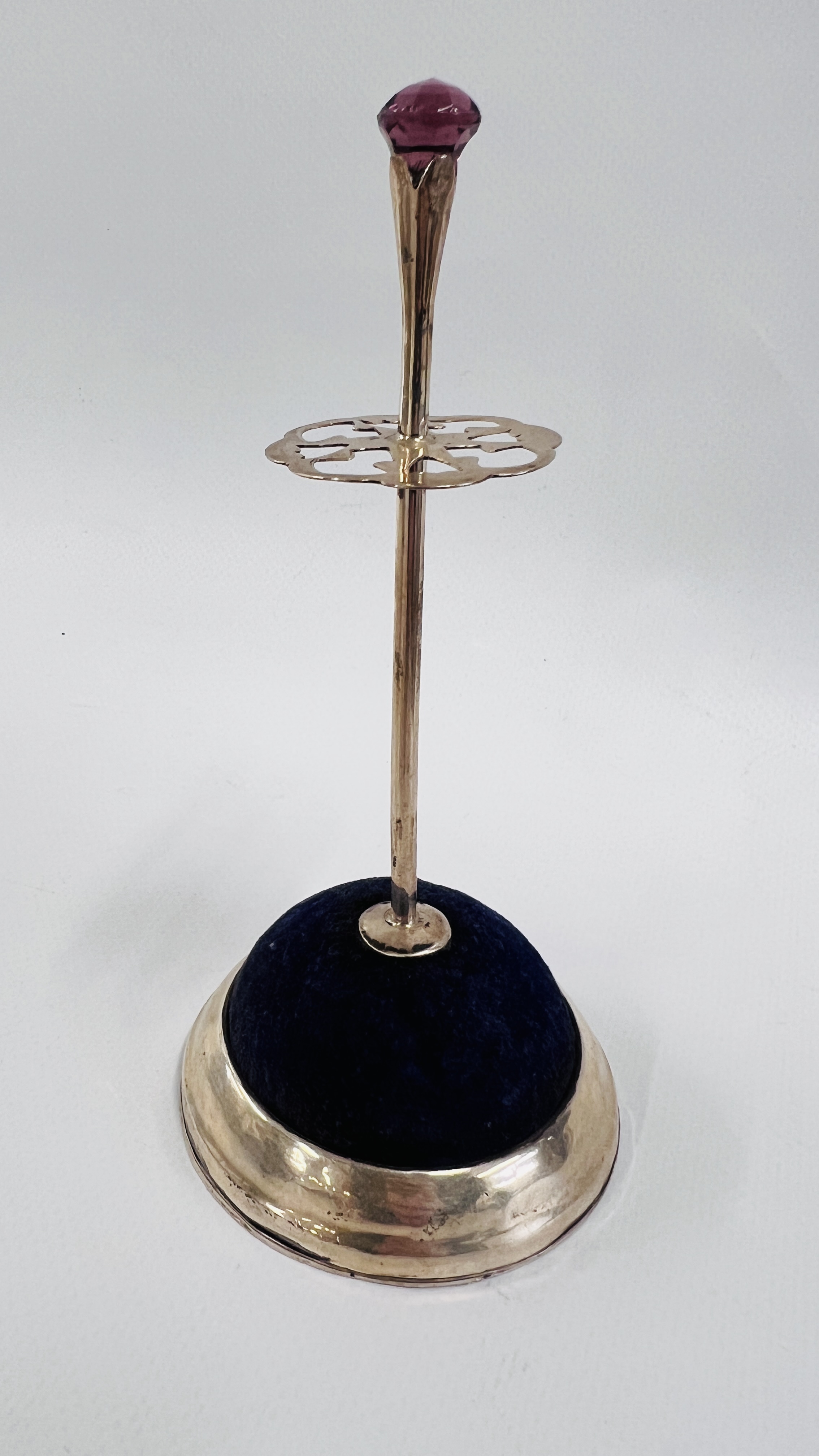 AN ANTIQUE SCOTTISH INSPIRED SILVER HAT PIN STAND, THE FINIAL SET WITH AN AMETHYST COLOURED STONE,