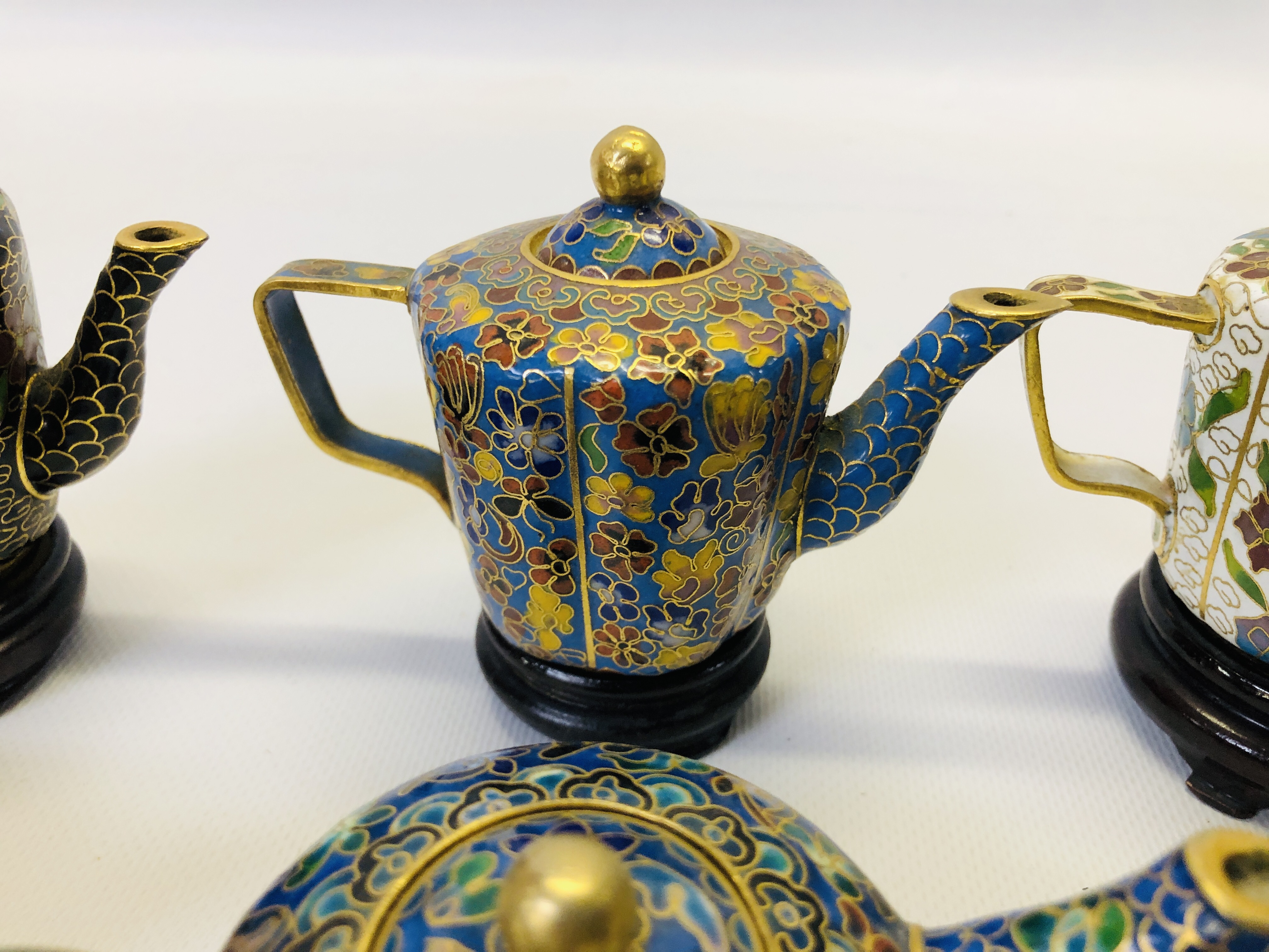 A COLLECTION OF 9 MINIATURE ORIENTAL ENAMELLED TEAPOTS ON CARVED HARDWOOD STANDS. - Image 6 of 12