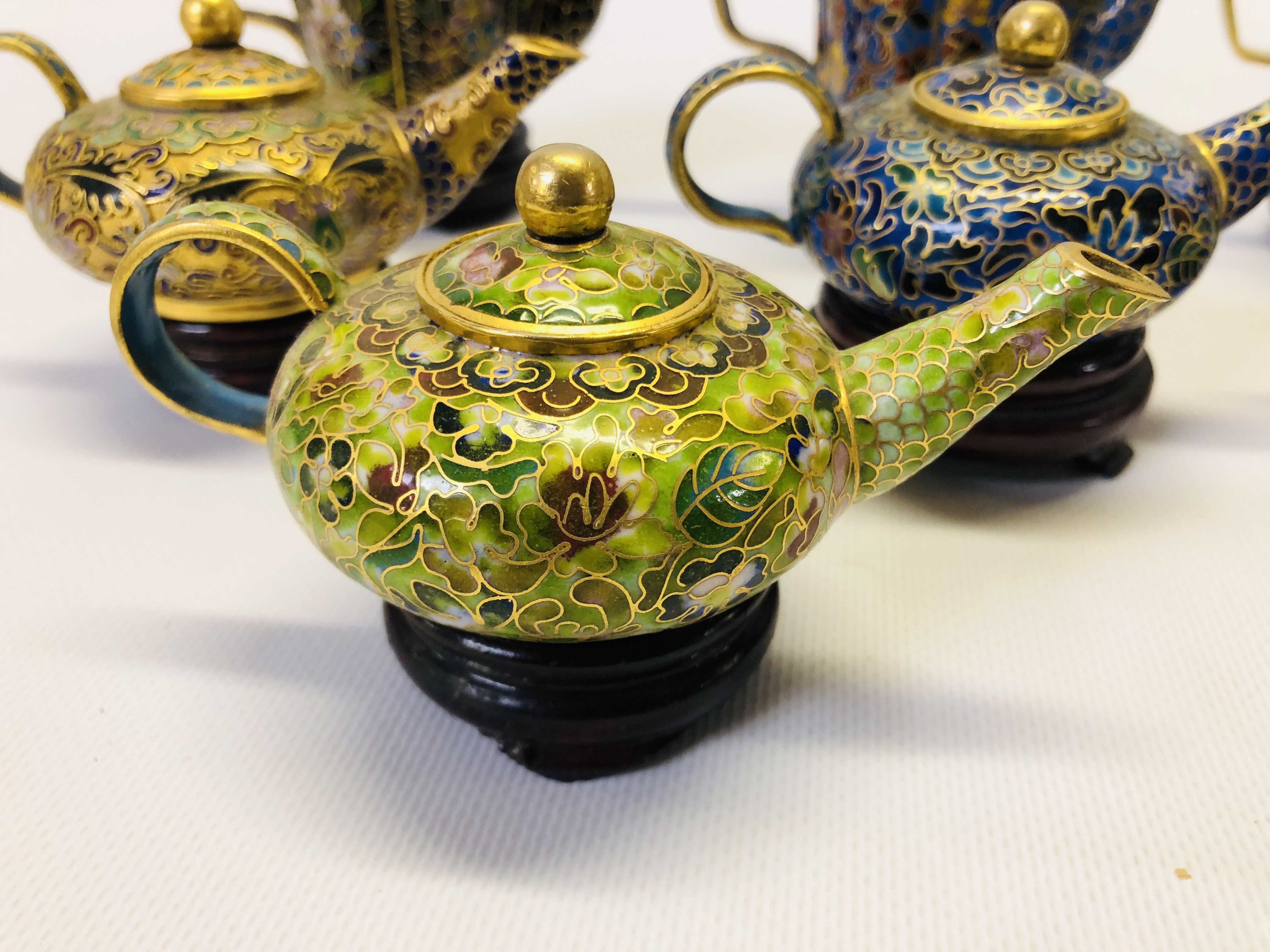 A COLLECTION OF 9 MINIATURE ORIENTAL ENAMELLED TEAPOTS ON CARVED HARDWOOD STANDS. - Image 2 of 12