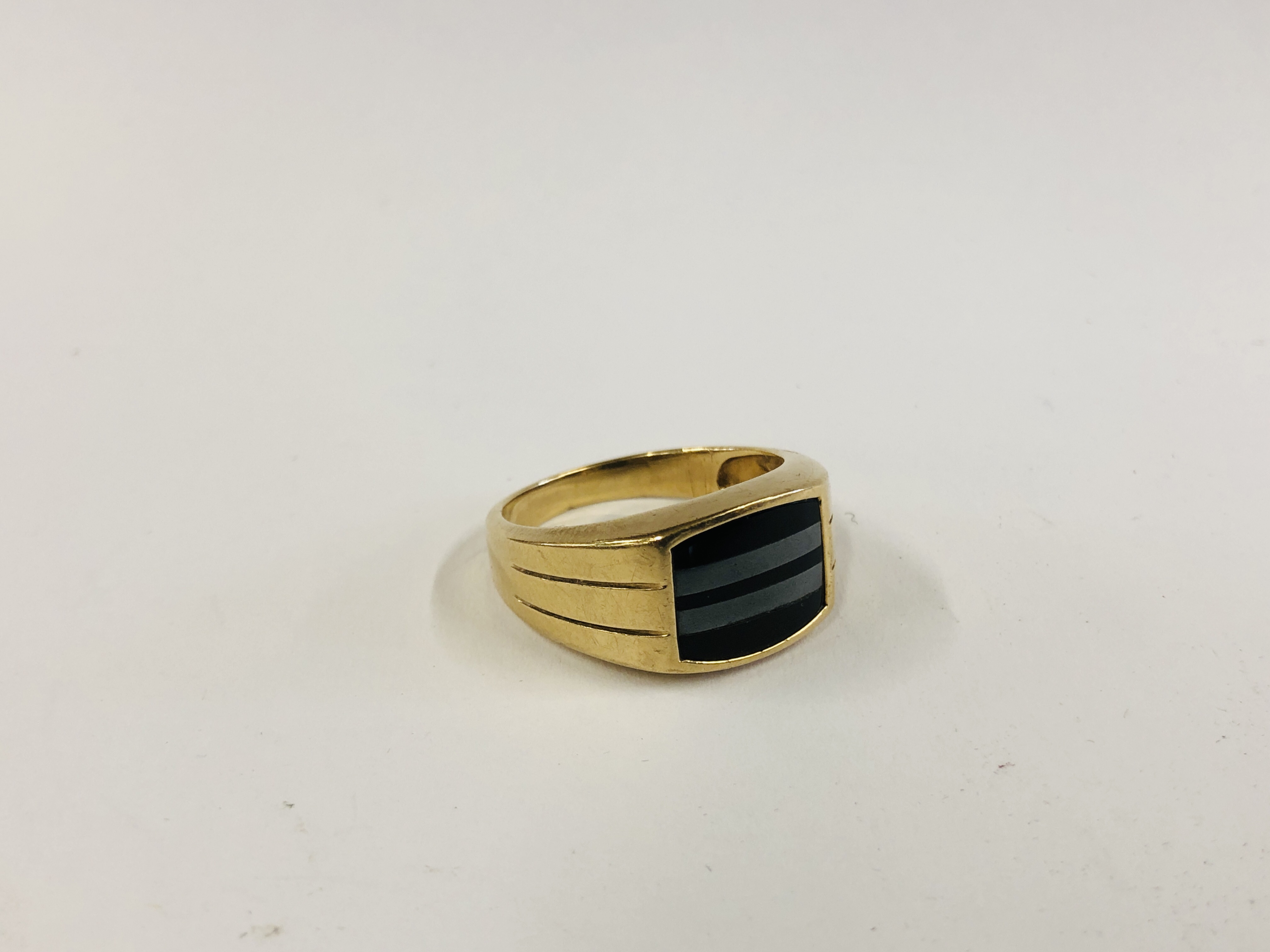 A GENT'S 9CT GOLD ONYX PANEL RING.