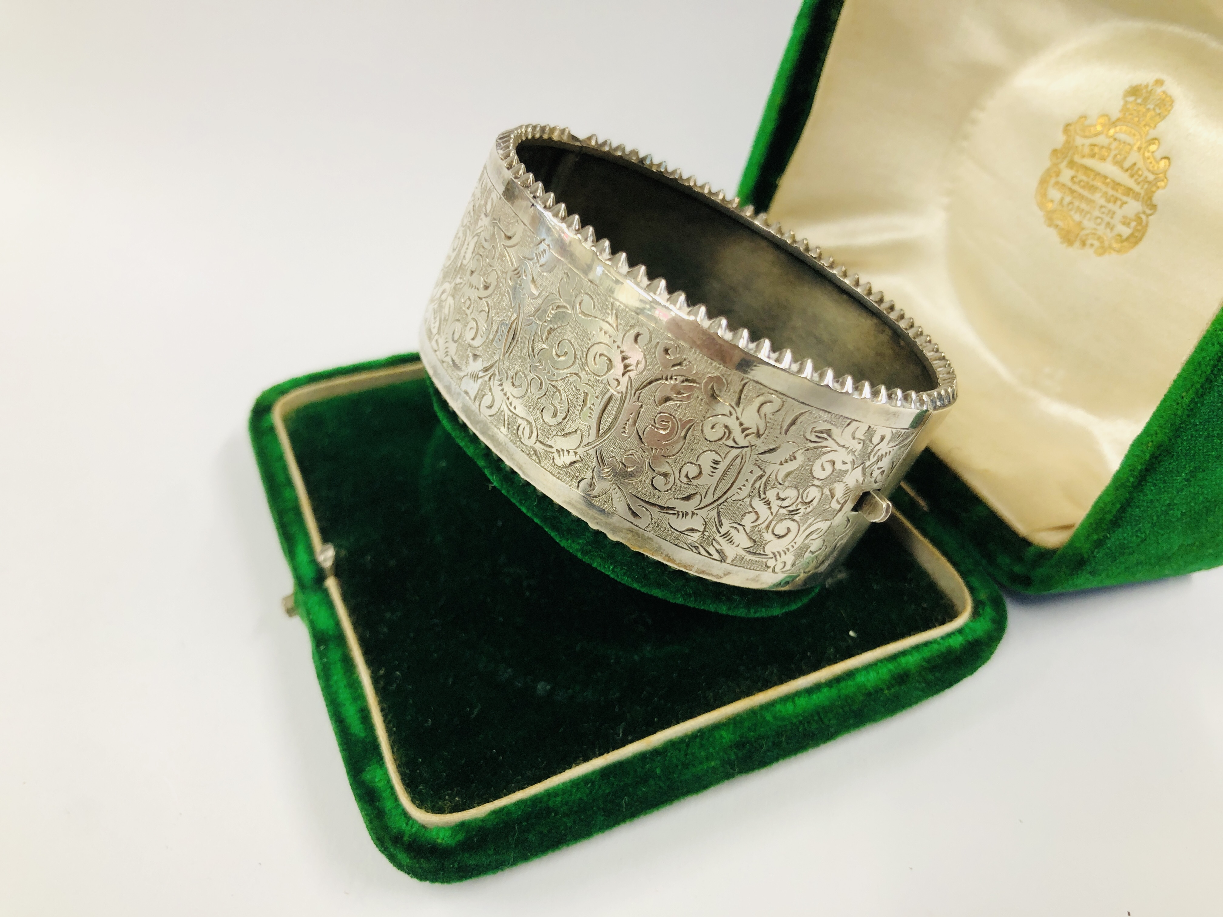 A VINTAGE WHITE METAL ENGRAVED HINGED BANGLE IN AN ANTIQUE GREEN VELVET BOX MARKED "THE ALEX CLARK" - Image 4 of 11