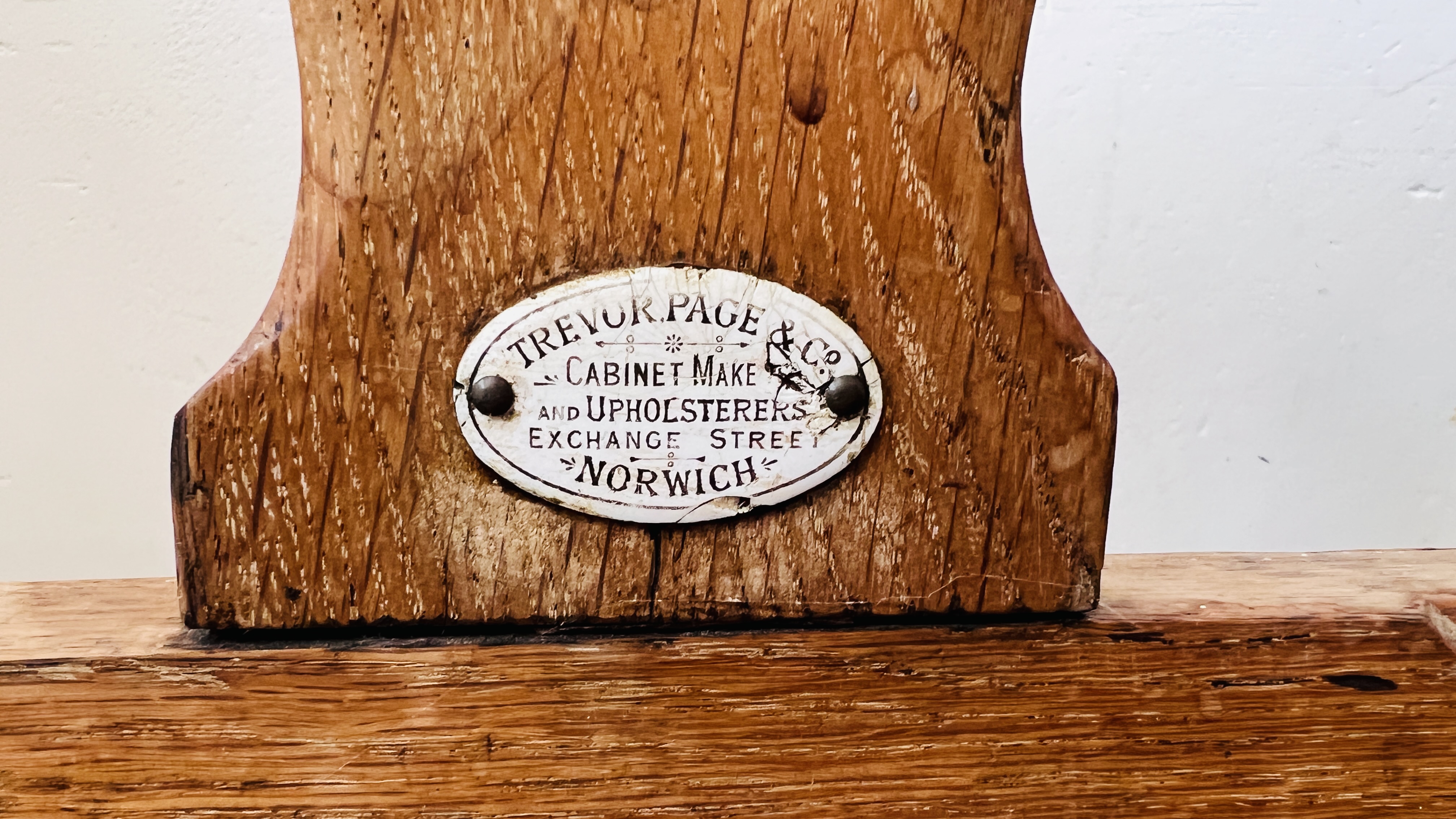 AN ANTIQUE OAK WAITING ROOM BENCH BEARING TREVOR PAGE & Co NORWICH CABINET MAKER LABEL, - Image 3 of 16