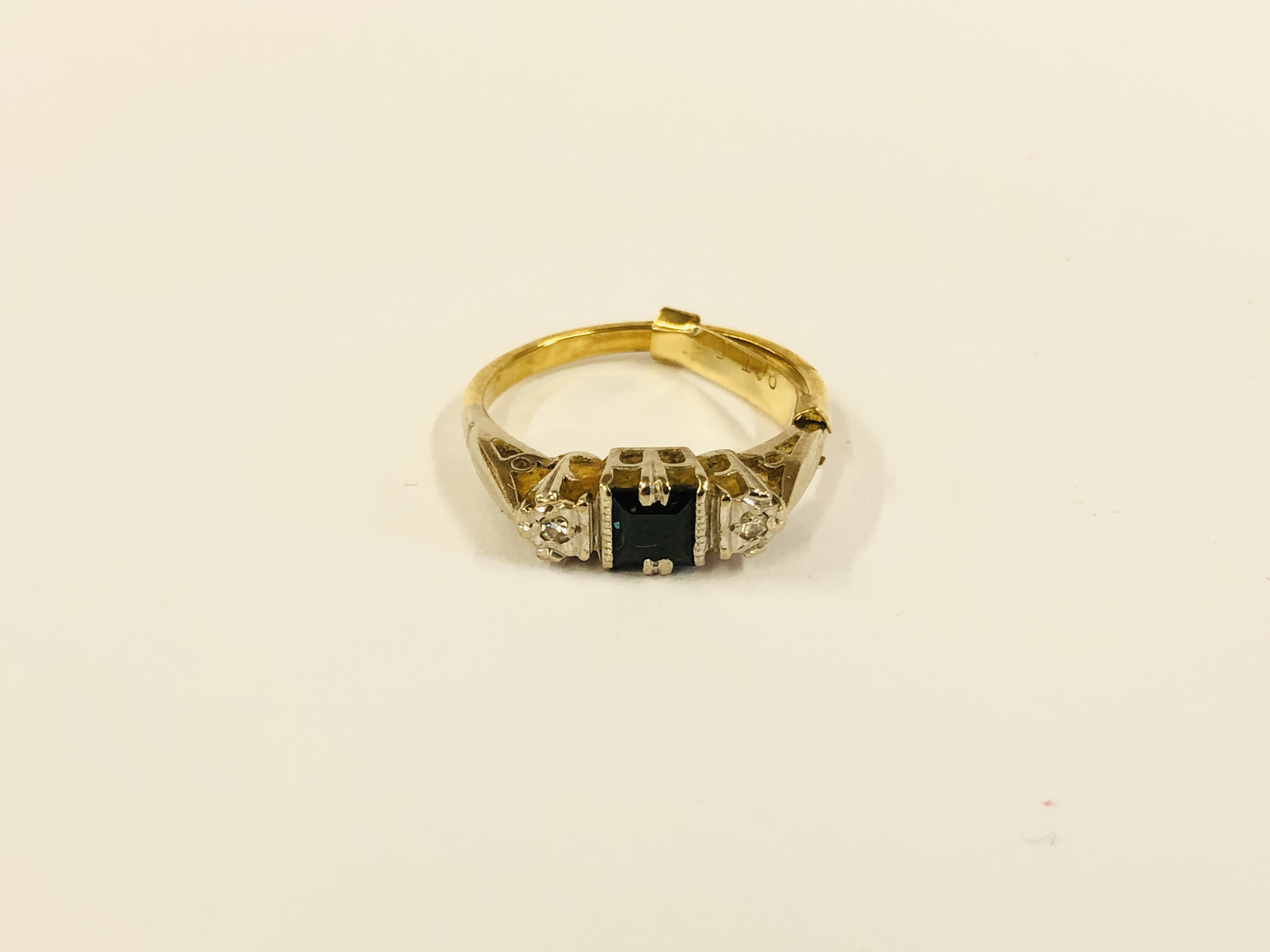 AN 18CT GOLD RING SET WITH CENTRAL BLUE SQUARE STONE AND A DIAMOND TO EITHER SIDE.