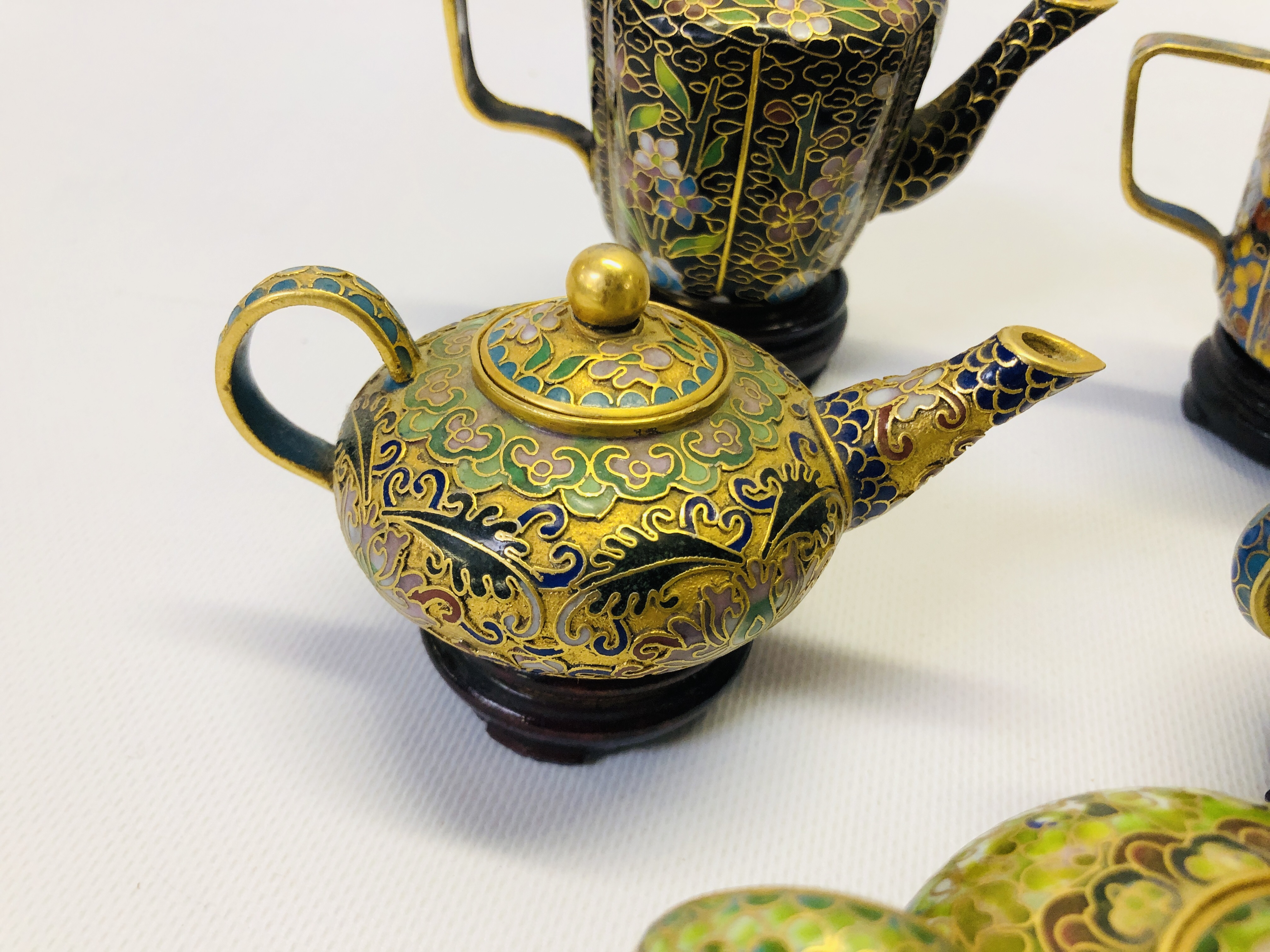 A COLLECTION OF 9 MINIATURE ORIENTAL ENAMELLED TEAPOTS ON CARVED HARDWOOD STANDS. - Image 4 of 12