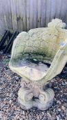 A CONCRETE GARDEN SEAT WITH SCROLL DETAIL.