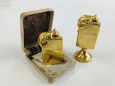 TWO GILT FINISH CAT SCULPTURE ZIPPO LIGHTERS, ONE CASED EXAMPLE, THE OTHER ON A PEDESTAL STAND.