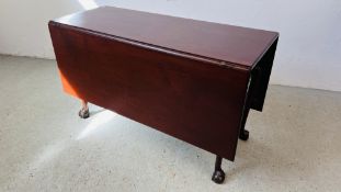 AN ANTIQUE MAHOGANY DROP FLAP TABLE ON BALL AND CLAW FEET.