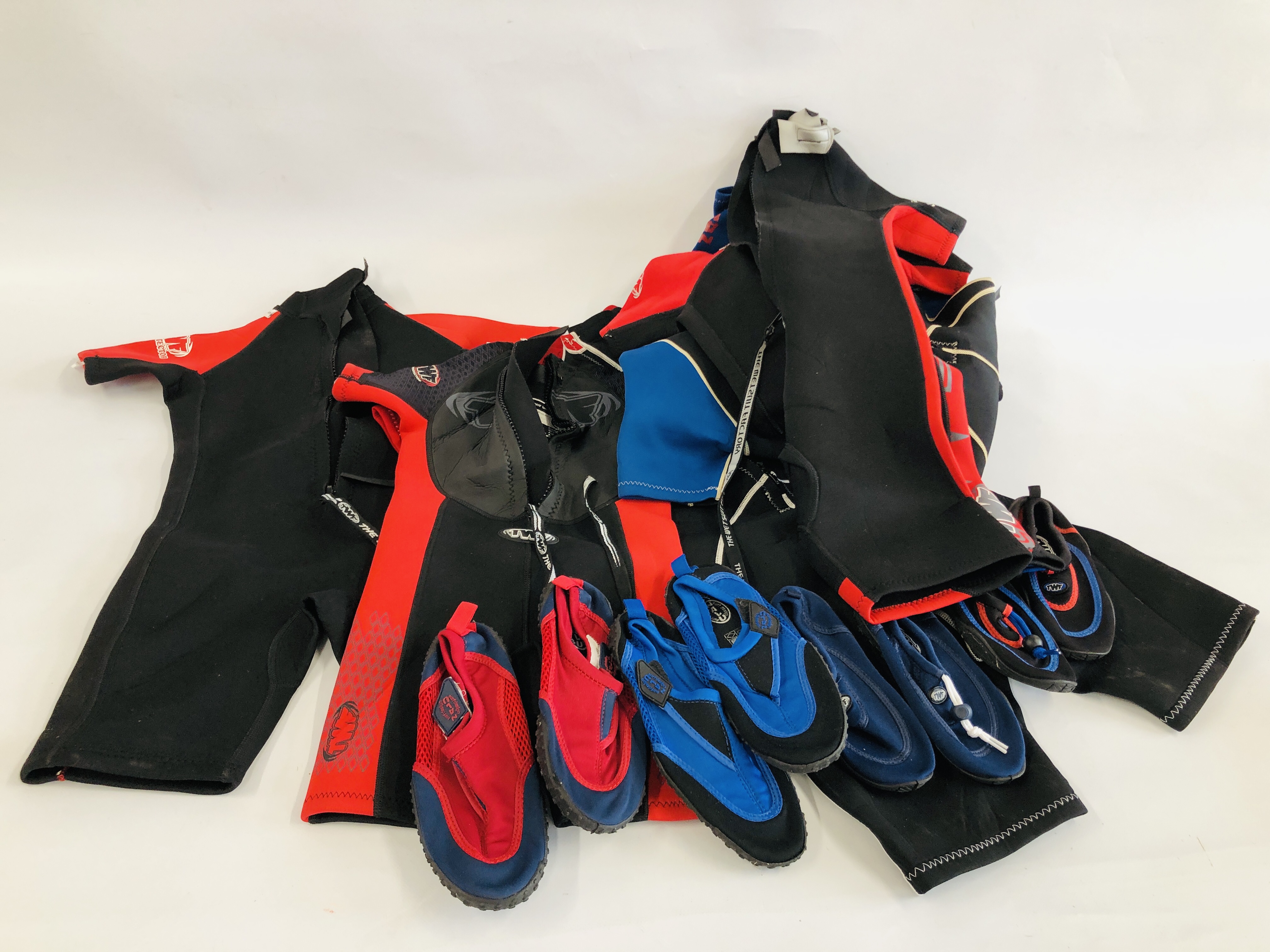 A GROUP OF 7 KIDS WET SUITS INCLUDING SIZES 11, 12 AND 8 + VARIOUS WATER SHOES.