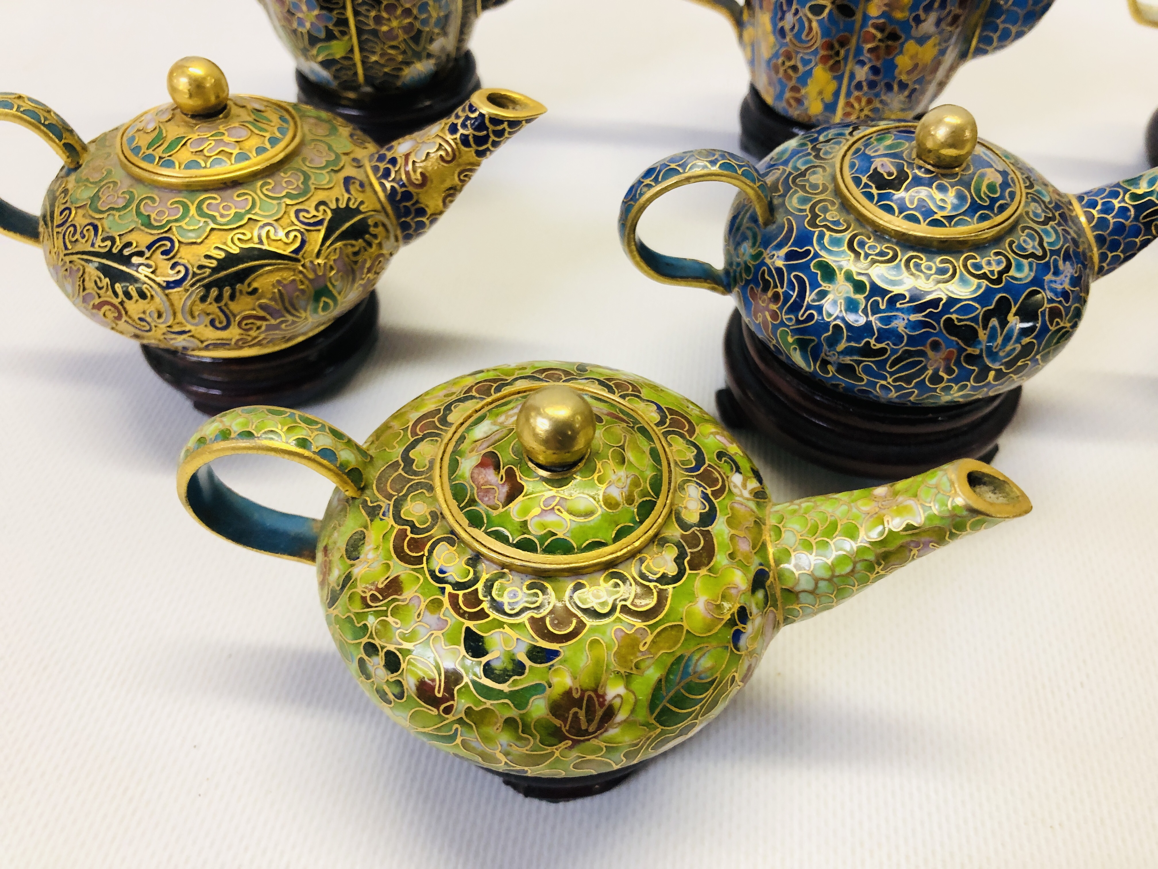 A COLLECTION OF 9 MINIATURE ORIENTAL ENAMELLED TEAPOTS ON CARVED HARDWOOD STANDS. - Image 3 of 12