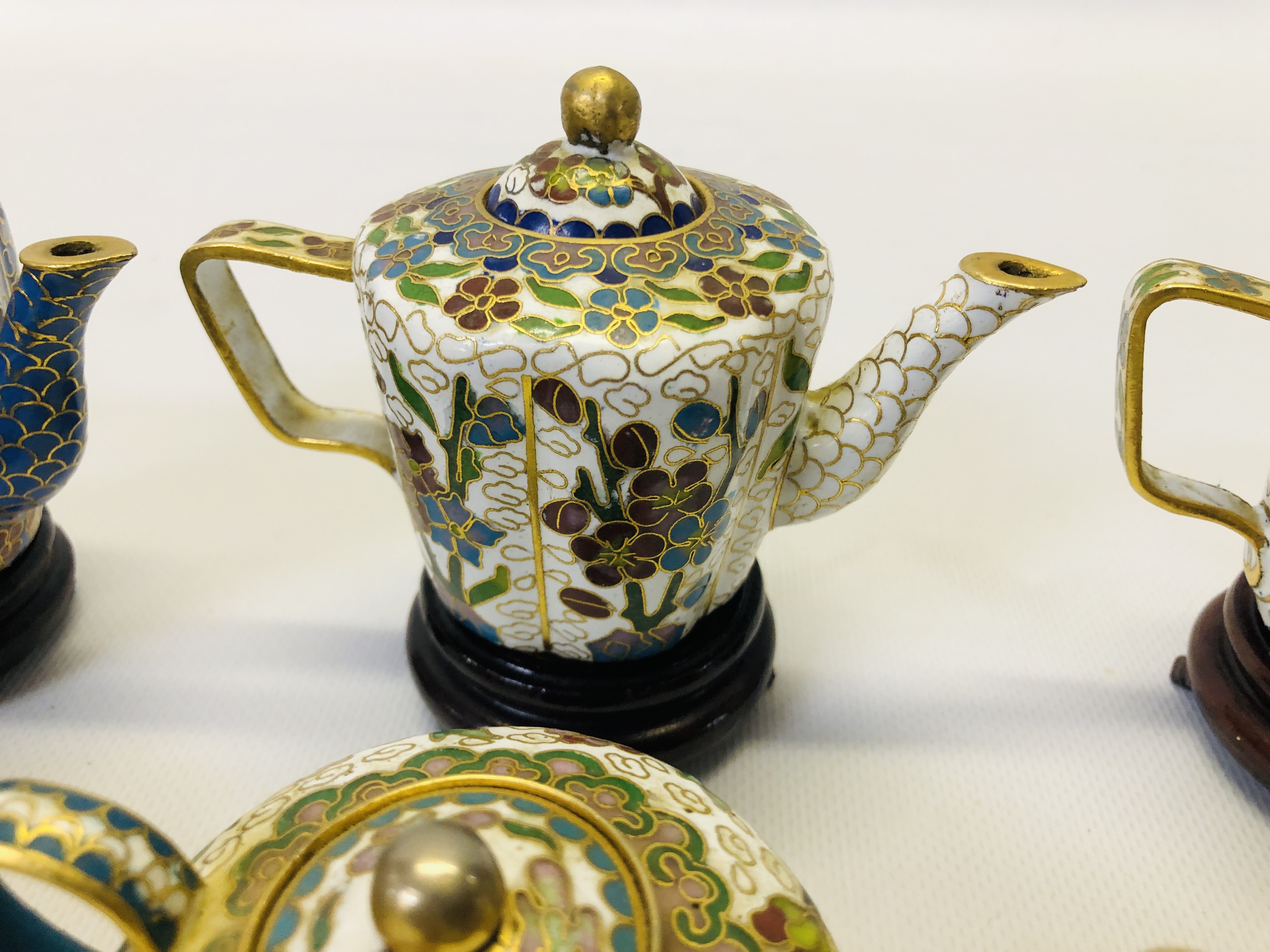 A COLLECTION OF 9 MINIATURE ORIENTAL ENAMELLED TEAPOTS ON CARVED HARDWOOD STANDS. - Image 9 of 12