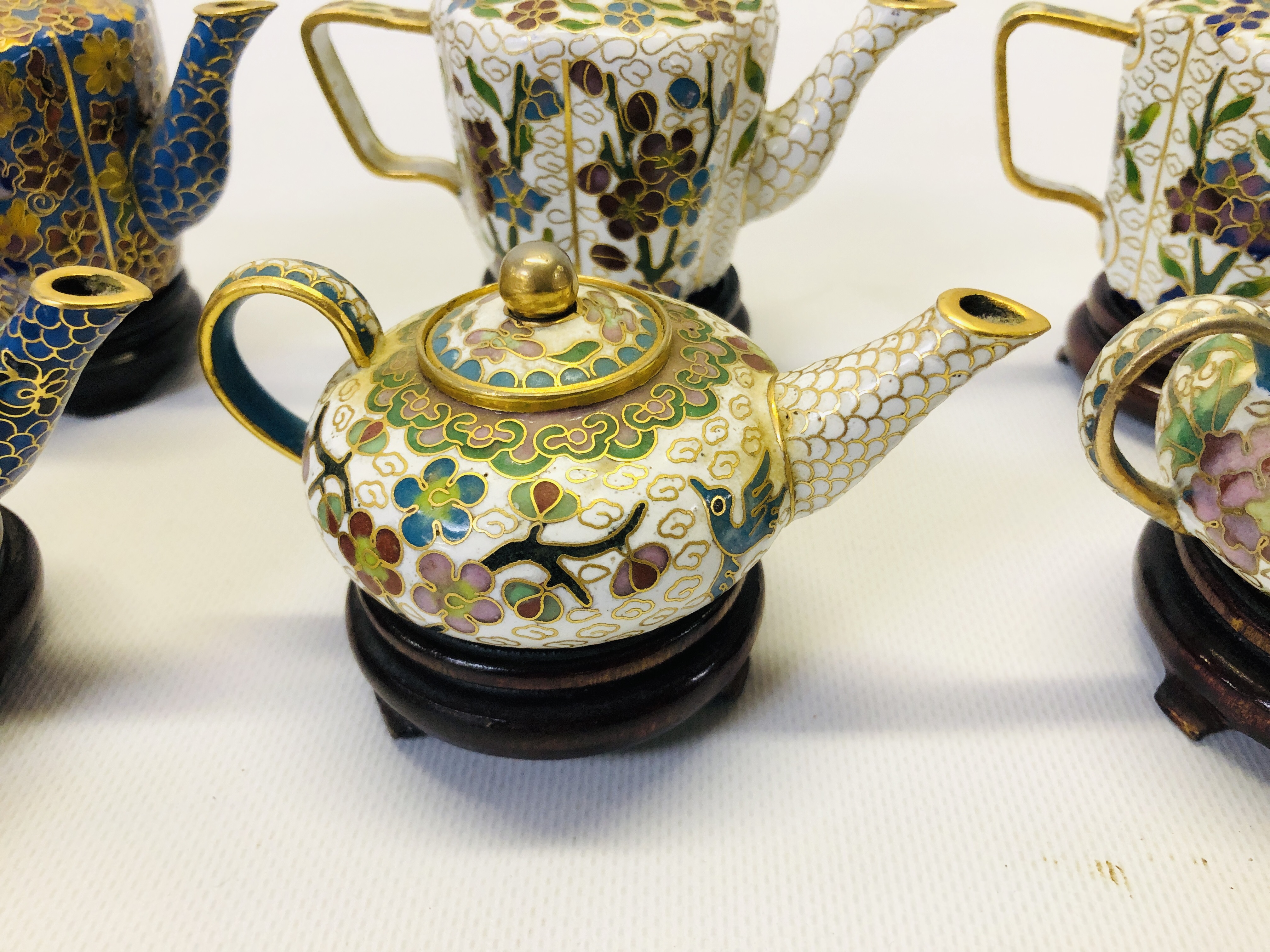 A COLLECTION OF 9 MINIATURE ORIENTAL ENAMELLED TEAPOTS ON CARVED HARDWOOD STANDS. - Image 8 of 12