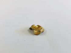 A YELLOW METAL TOOTH CROWN