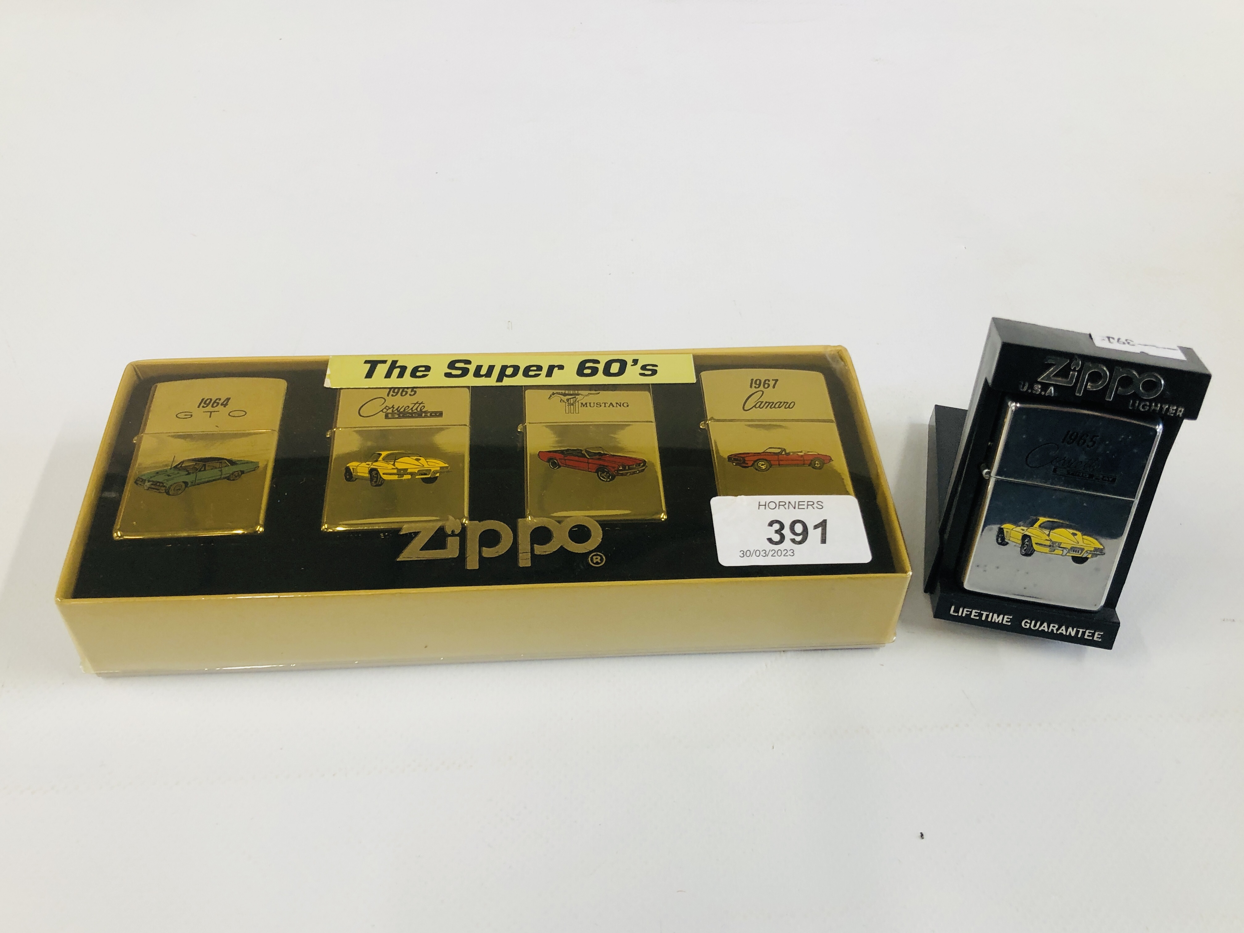 A BOXED "THE SUPER 60'S" ZIPPO LIGHTER SET ALONG WITH ONE FURTHER CORVETTE EXAMPLE.