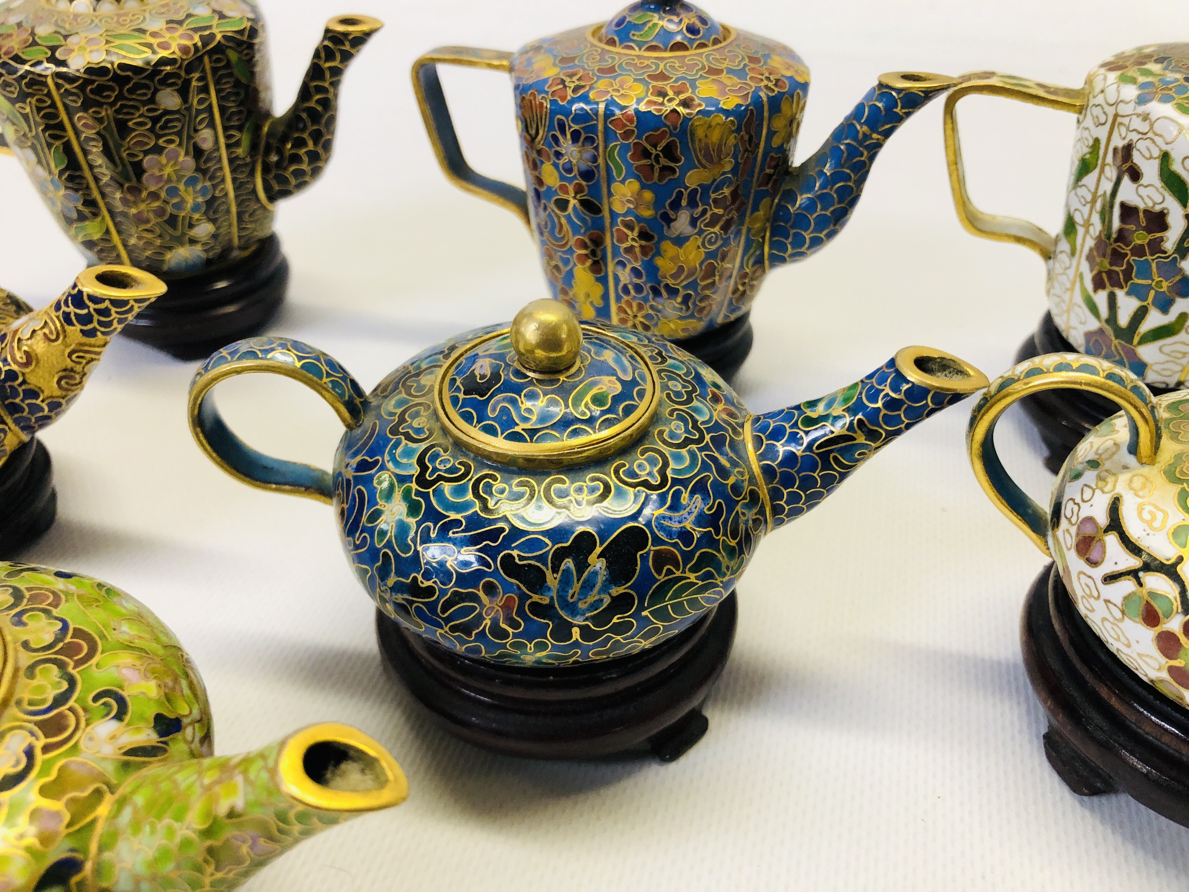A COLLECTION OF 9 MINIATURE ORIENTAL ENAMELLED TEAPOTS ON CARVED HARDWOOD STANDS. - Image 7 of 12