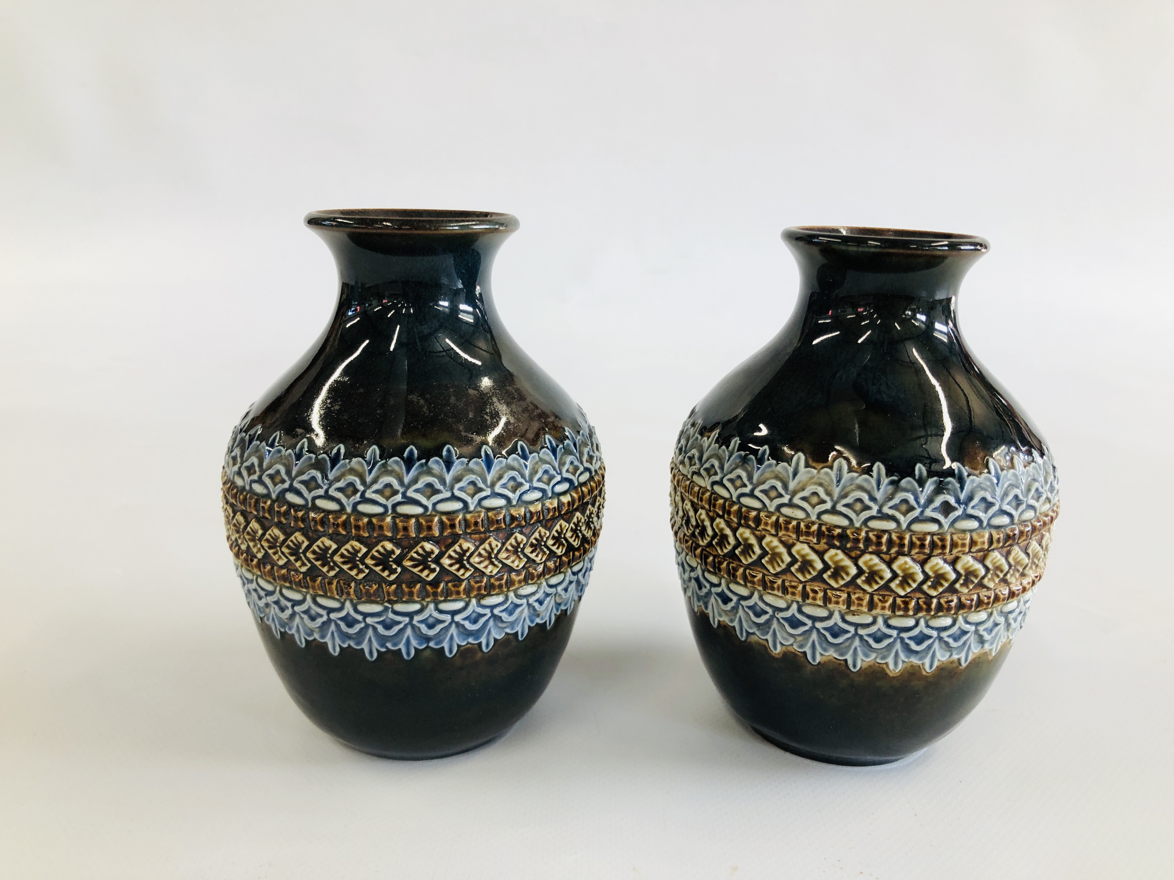 A PAIR OF DOULTON LAMBETH STONEWARE VASES - HEIGHT 15CM.