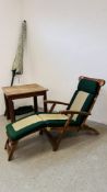 A RECLINING TEAK GARDEN STEAMER CHAIR WITH FOOT REST AND CUSHION ALONG WITH A SQUARE TEAK GARDEN