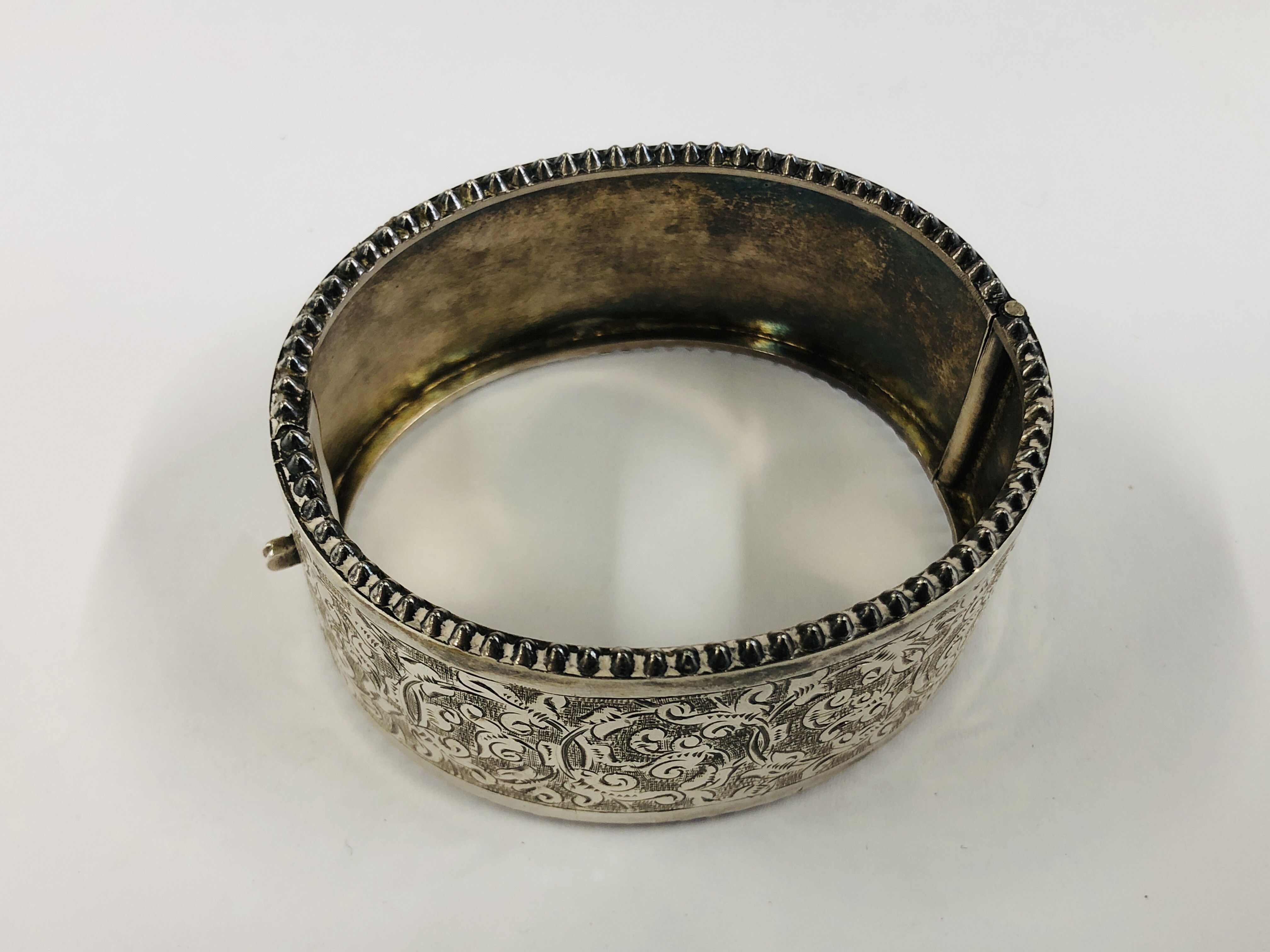 A VINTAGE WHITE METAL ENGRAVED HINGED BANGLE IN AN ANTIQUE GREEN VELVET BOX MARKED "THE ALEX CLARK" - Image 9 of 11