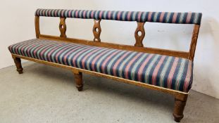 AN ANTIQUE OAK WAITING ROOM BENCH BEARING TREVOR PAGE & Co NORWICH CABINET MAKER LABEL,