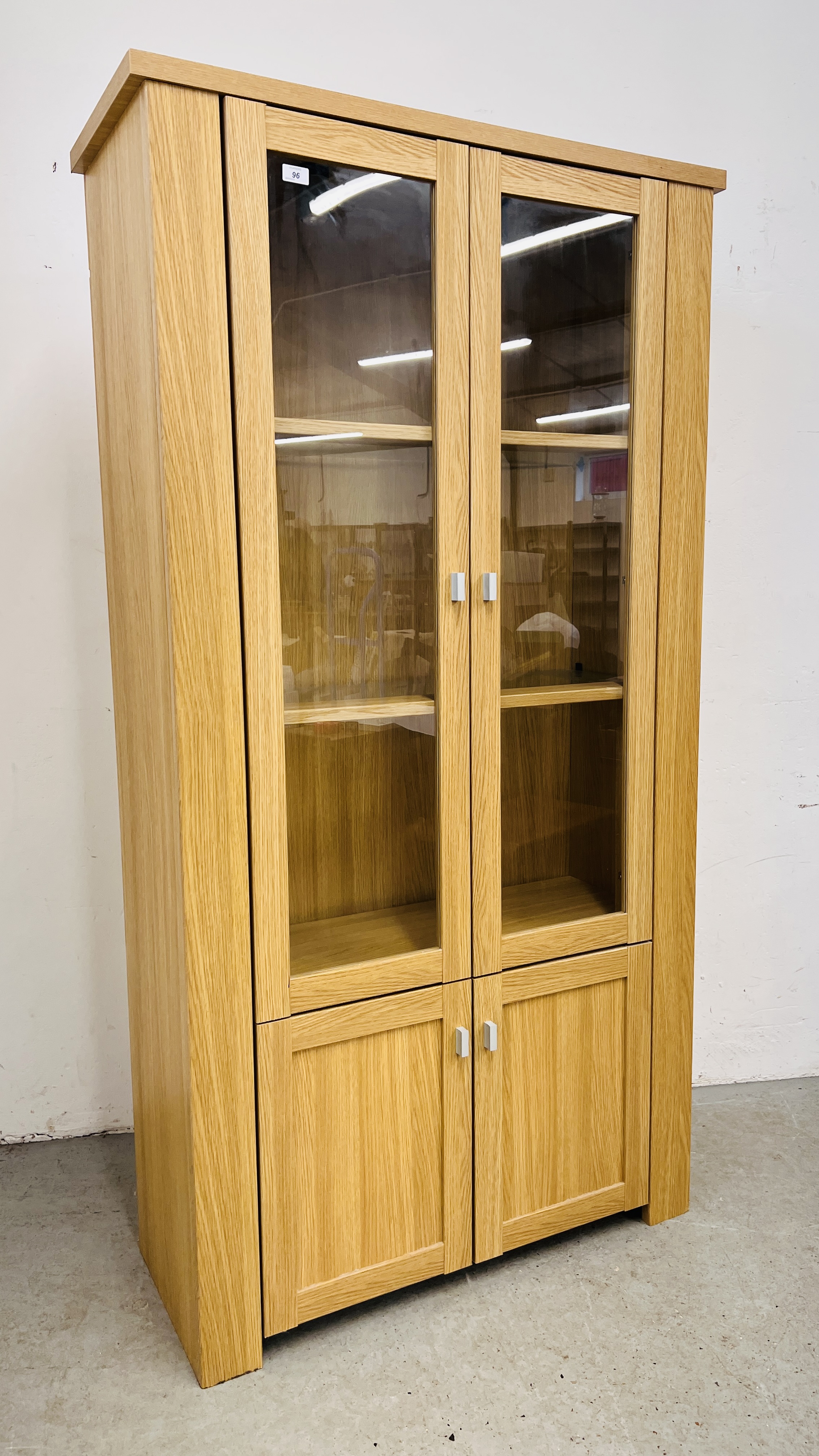 A MODERN LIGHT OAK FINISH DISPLAY CABINET WITH CUPBOARD BASE - W 100CM. D 40CM. H 188CM.