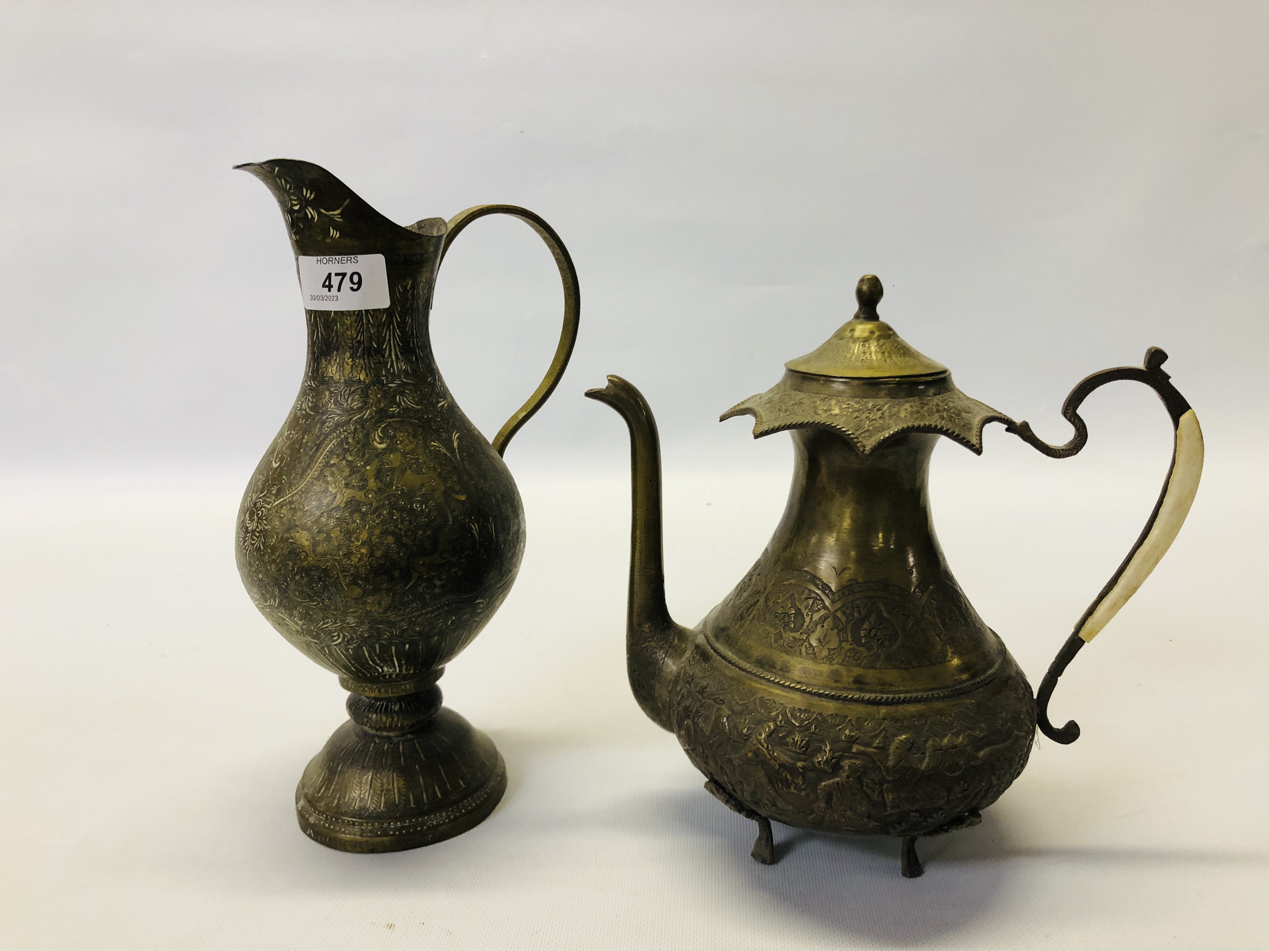 A VINTAGE MIDDLE EASTERN BRASS EWER ALONG WITH AN ELABORATE MIDDLE EASTERN BRASS COFFEE POT.