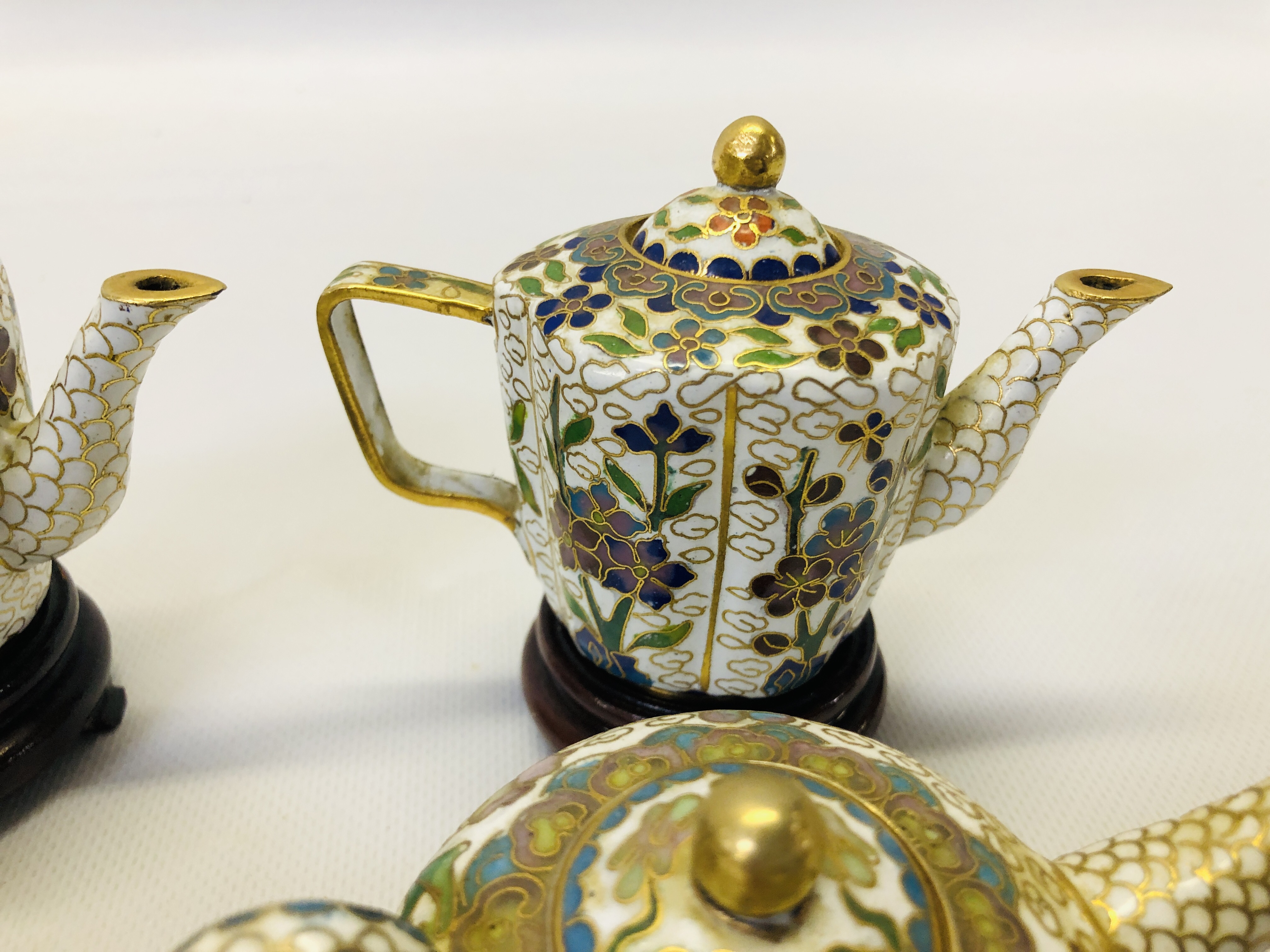 A COLLECTION OF 9 MINIATURE ORIENTAL ENAMELLED TEAPOTS ON CARVED HARDWOOD STANDS. - Image 10 of 12