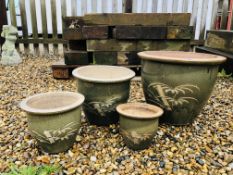 A SET OF FOUR GRADUATED GREEN GLAZED BAMBOO DESIGNED PLANTERS.