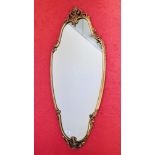 A GOOD QUALITY DECORATIVE GILT FINISHED CAST FRAMED WALL MIRROR - LENGTH 109CM.