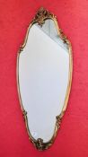 A GOOD QUALITY DECORATIVE GILT FINISHED CAST FRAMED WALL MIRROR - LENGTH 109CM.