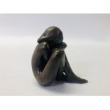 A CAST FIGURE BY D.J. SCALDWELL 20TH CENTURY MODED AS A GIRL HUNCHED OVER - HEIGHT 10CM.