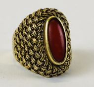 A DESIGNER YELLOW METAL RING, THE SHOULDER WORK OF WOVEN DESIGN SET WITH LOZENGE SHAPE STONE,