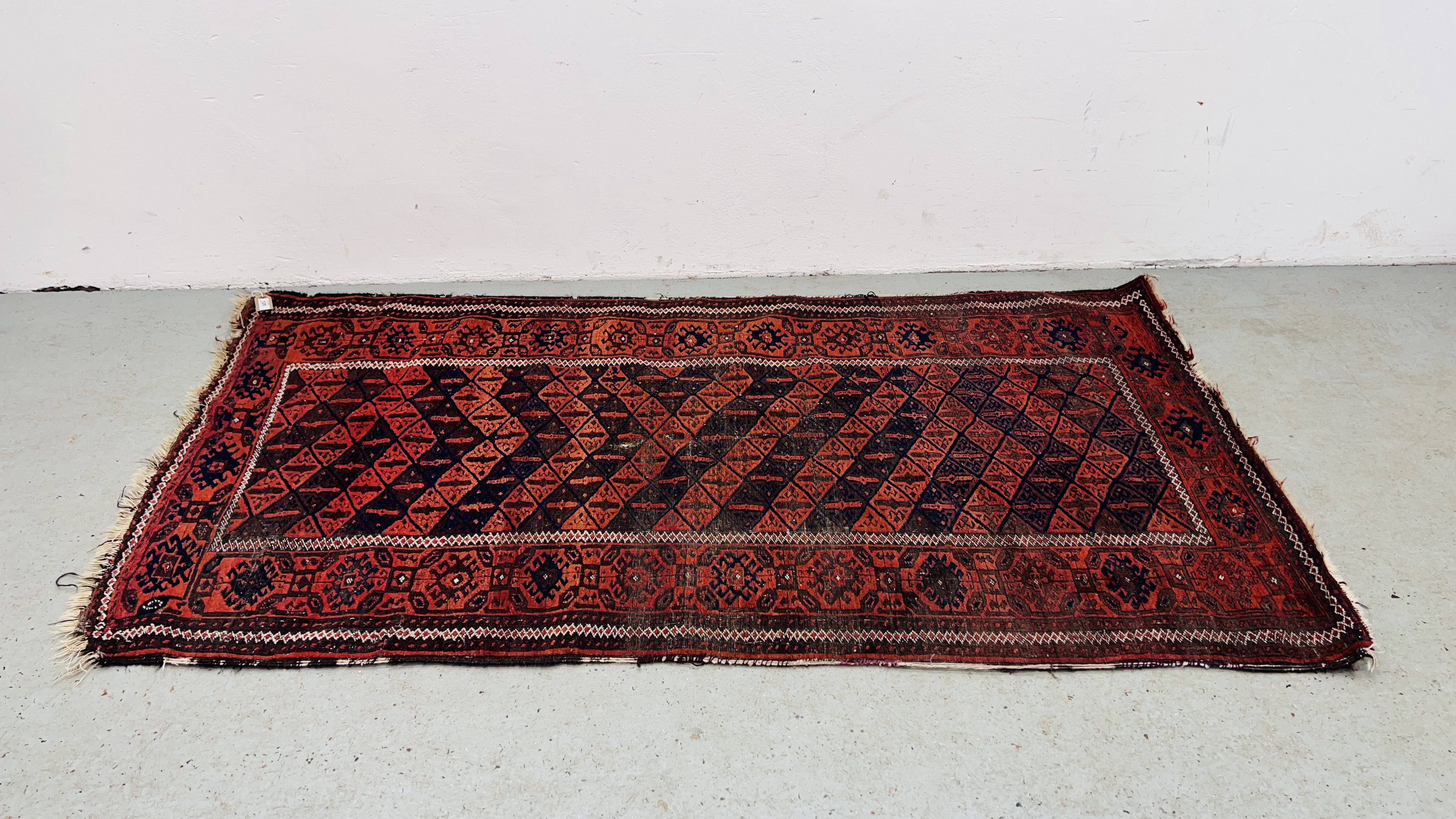 A TRADITIONAL BELOUCH RUG WITH A CENTRAL LATTICE WORK DESIGN (ORANGE / BLUE) 200 X 107CM.