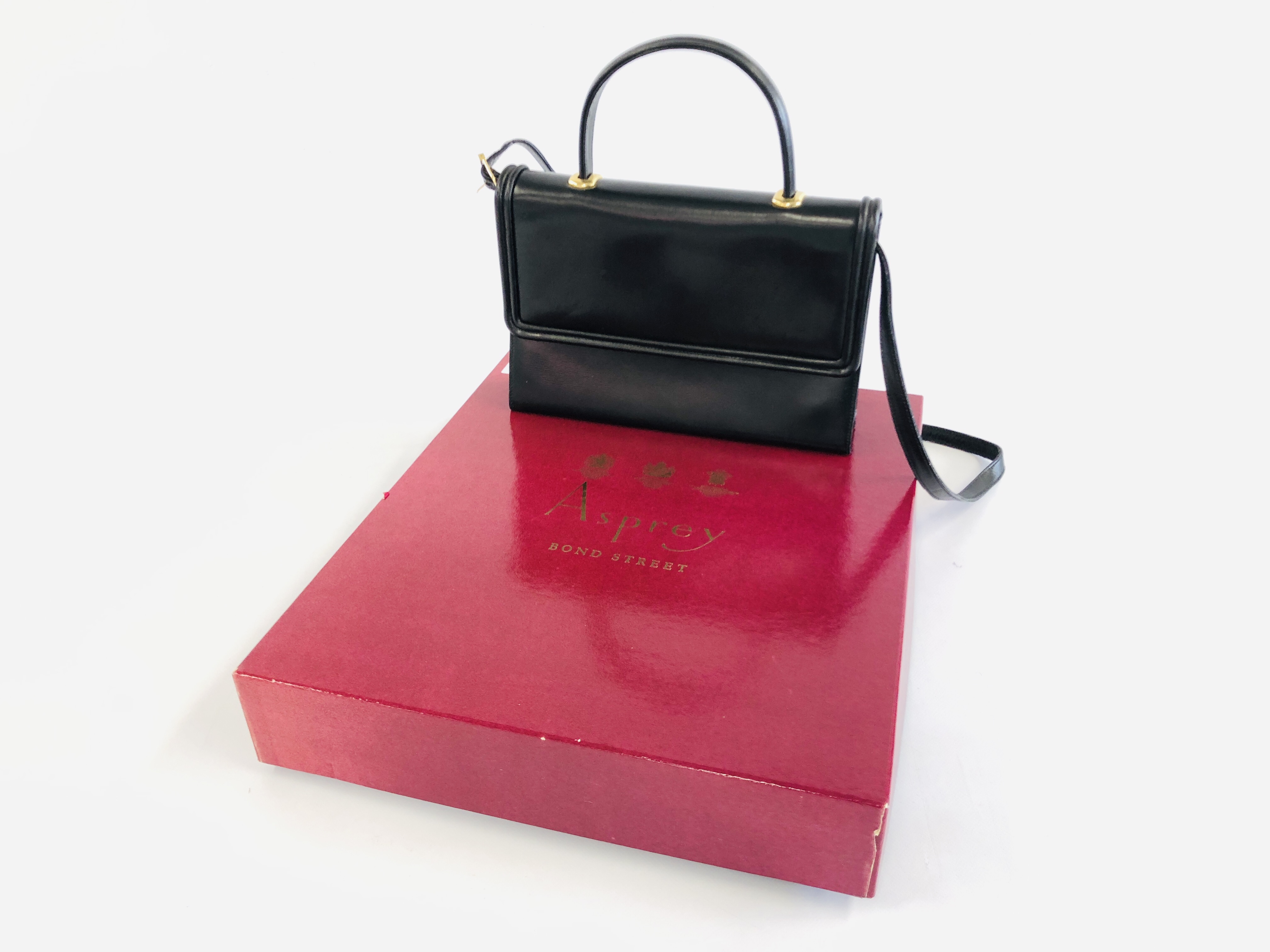 AN ASPREYS OF LONDON BLACK LEATHER BAG IN ORIGINAL BOX.