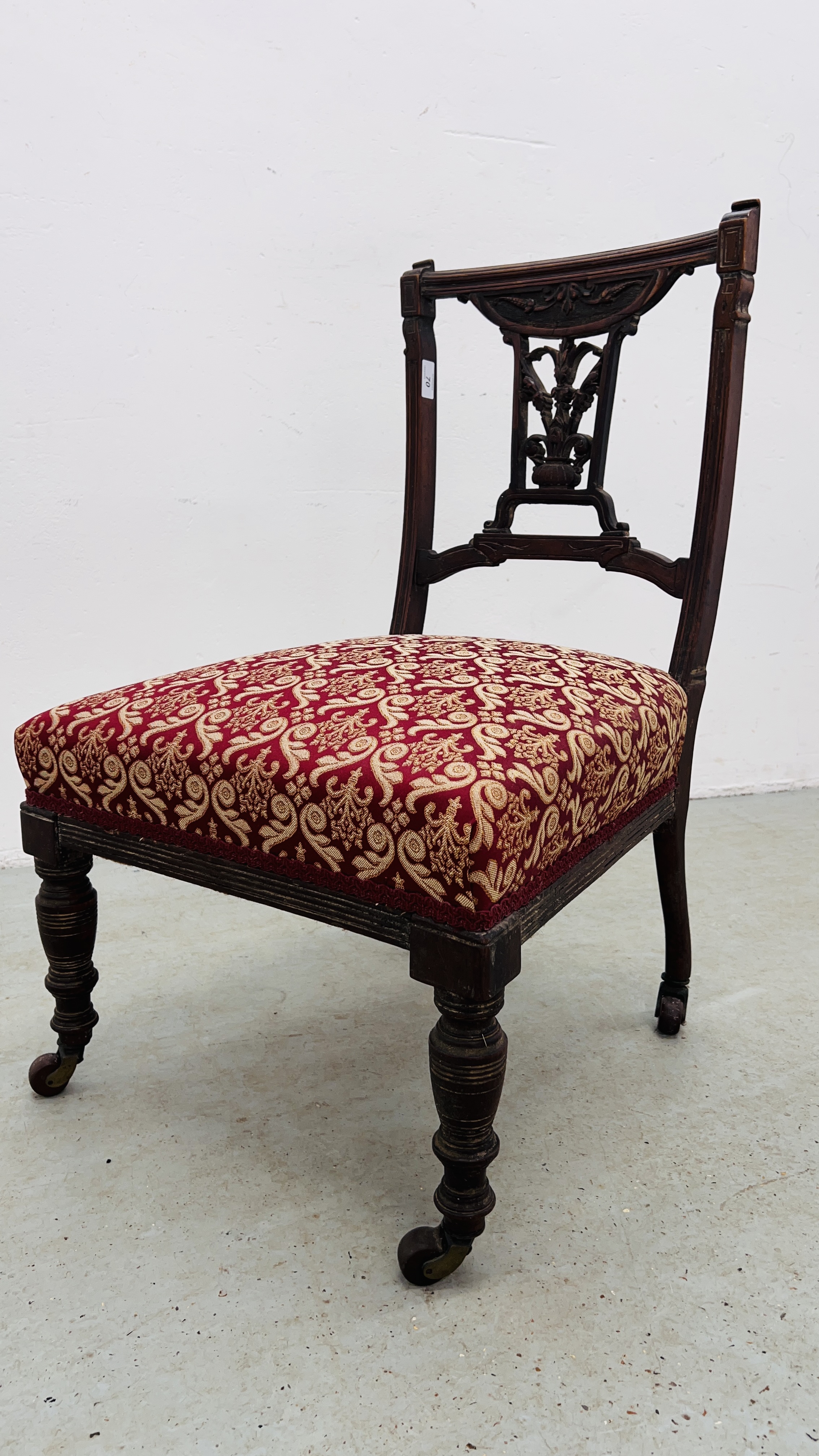 AN EDWARDIAN BEDROOM CHAIR WITH CARVED DETAILING AND UPHOLSTERED SEAT.